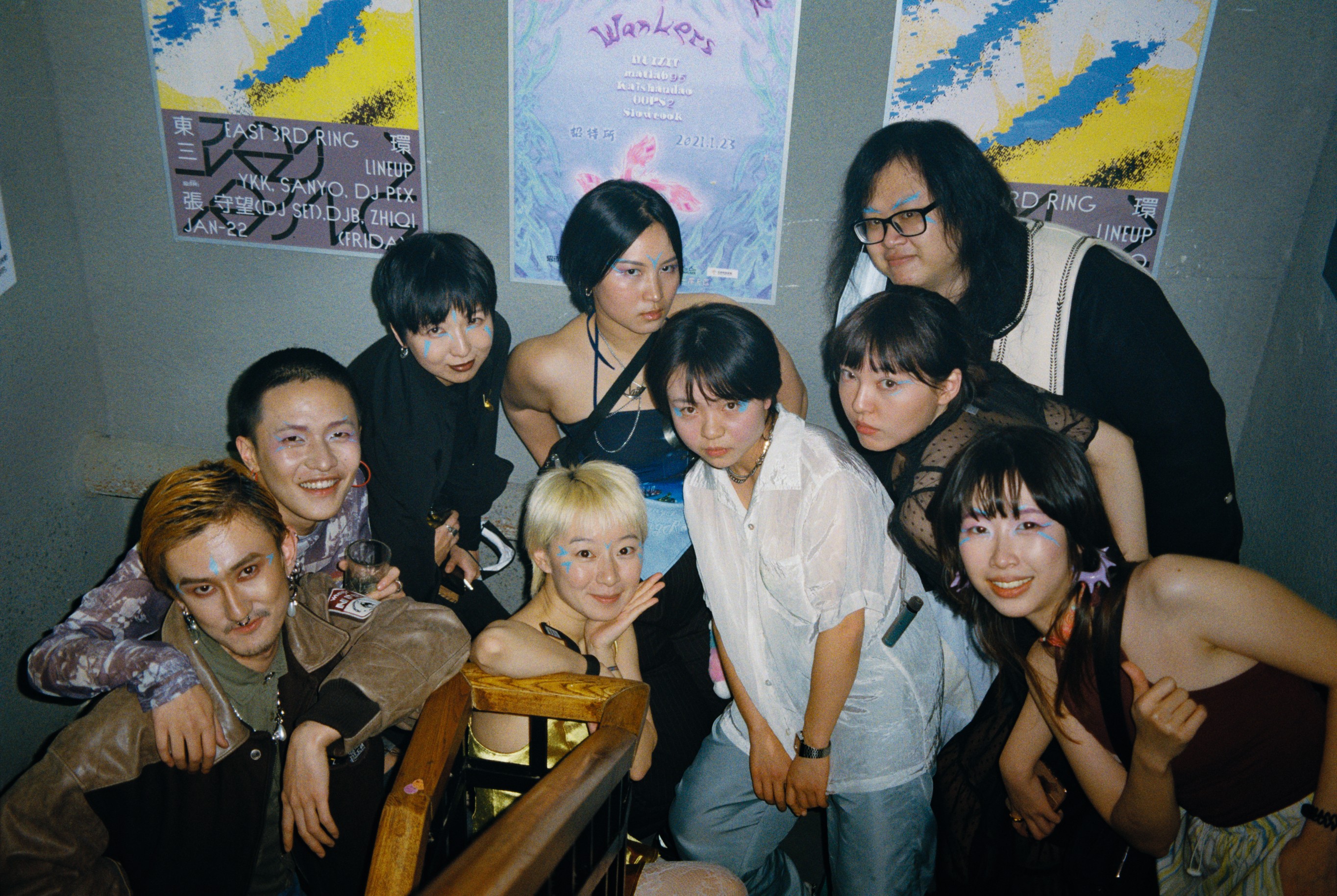 A group of friends posing closely together for a photo at an indoor event.