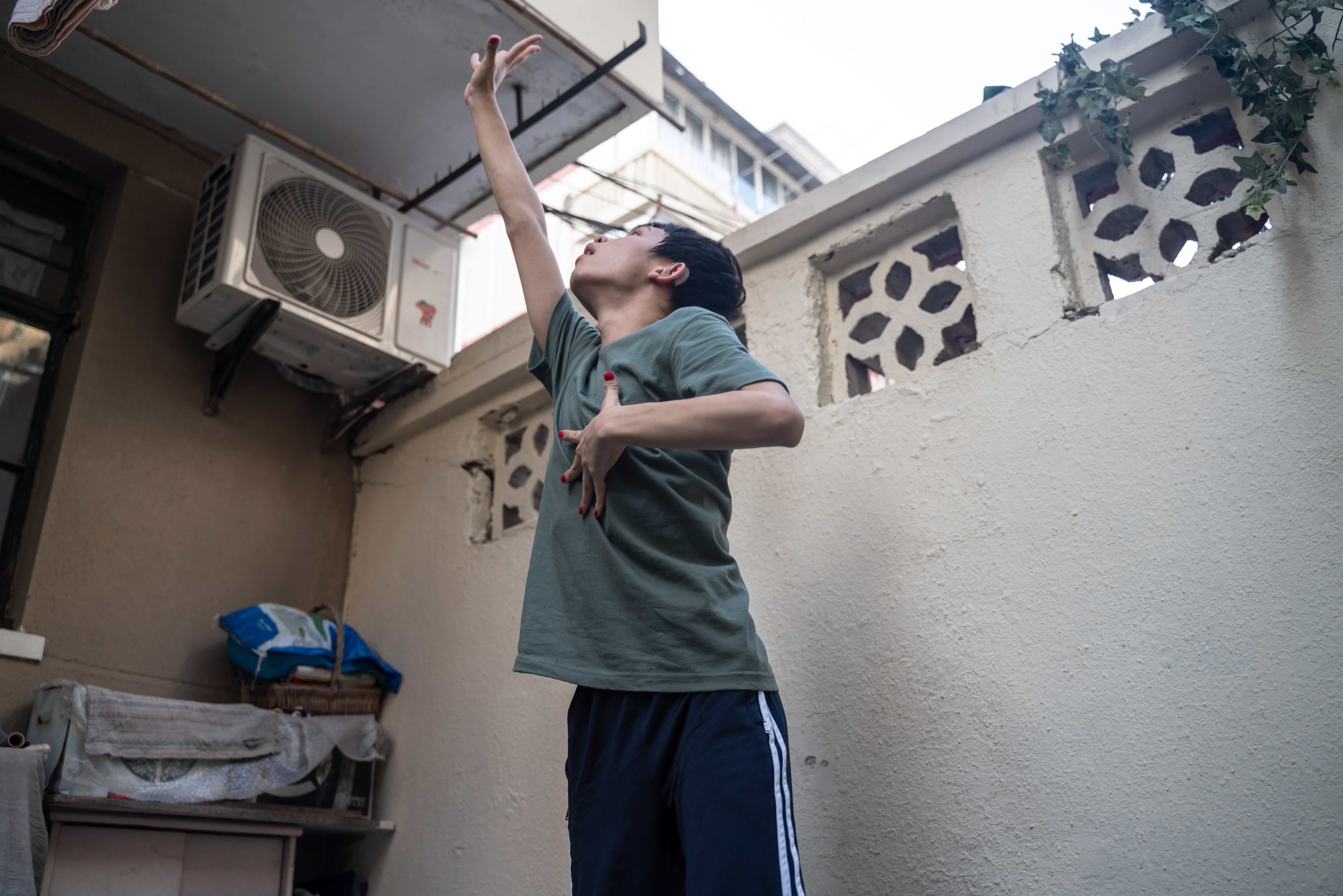A boy stretches his right arm upwards.