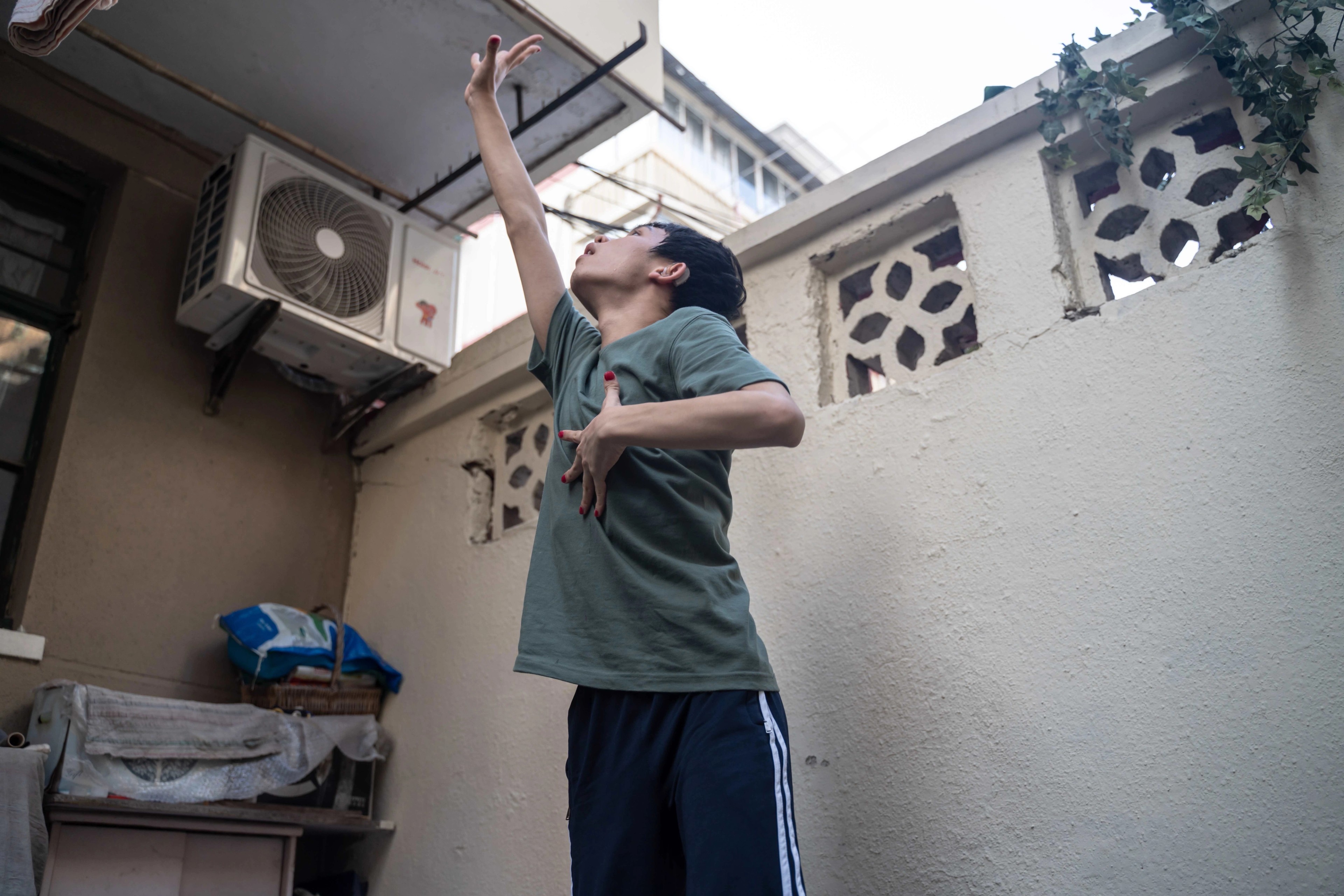 A boy stretches his right arm upwards.