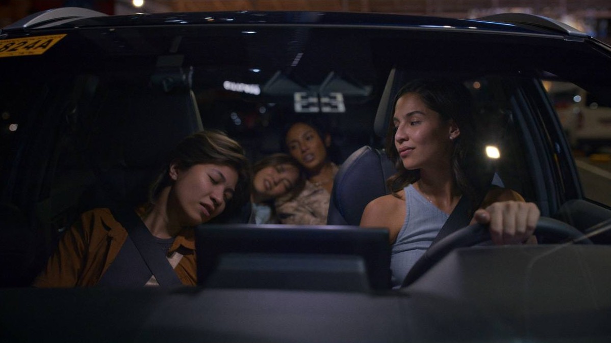 A woman driving at night with several passengers asleep in the car.