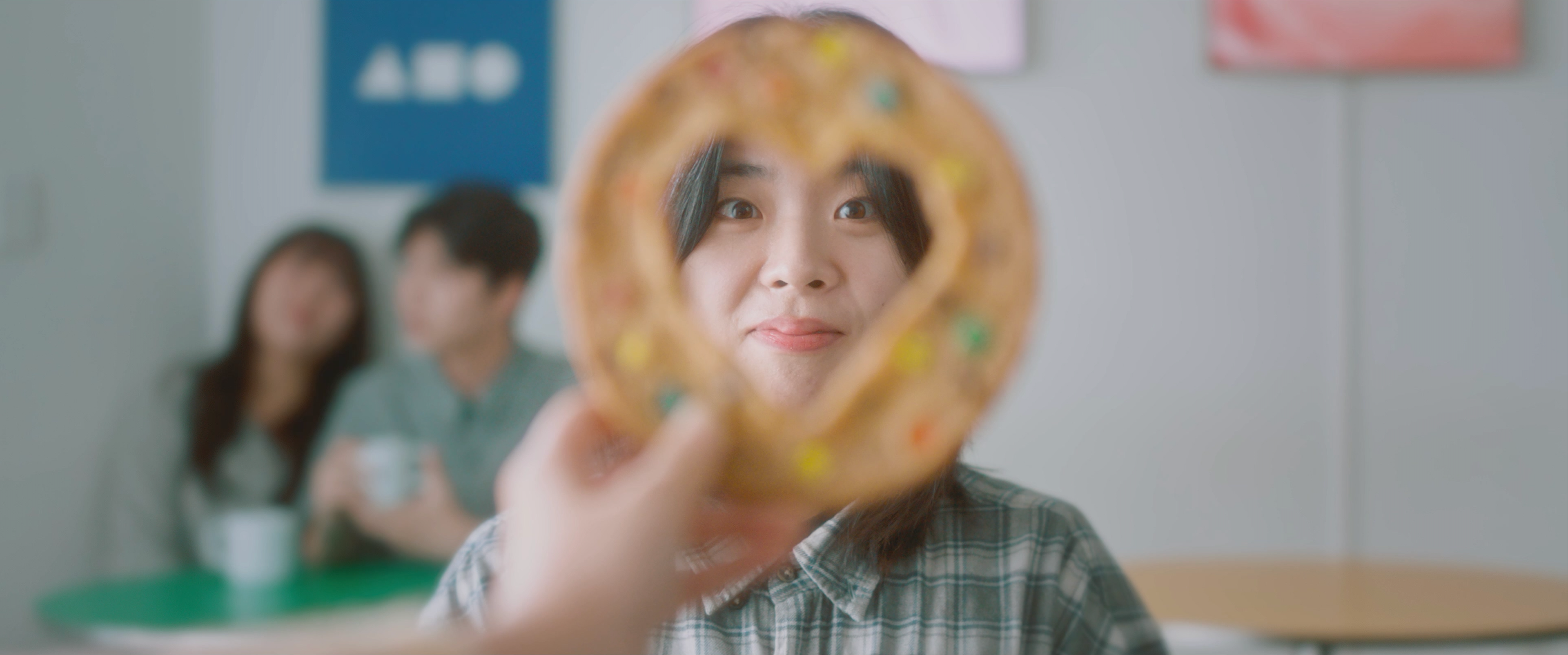 a woman's face is framed through a heart-shaped cookie.