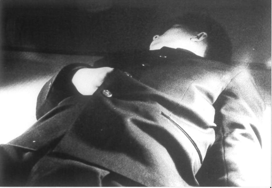 A man is lying on the floor with his head turned to the side.
