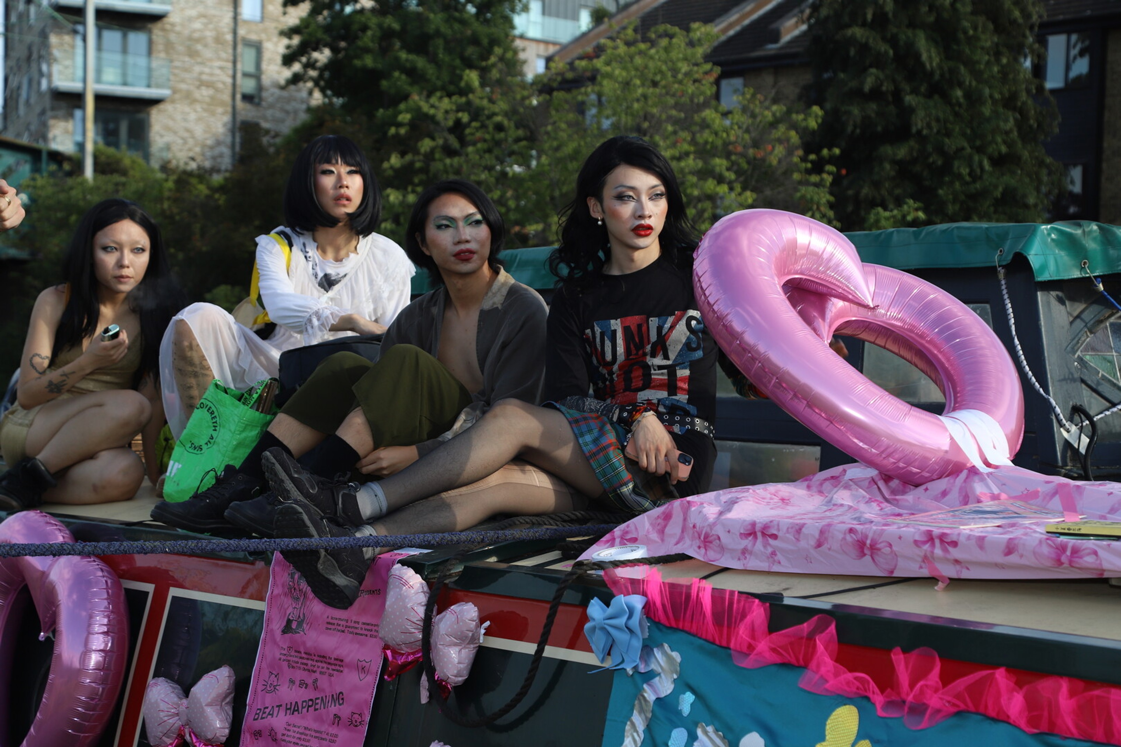 four figures sit on top of a houseboat.