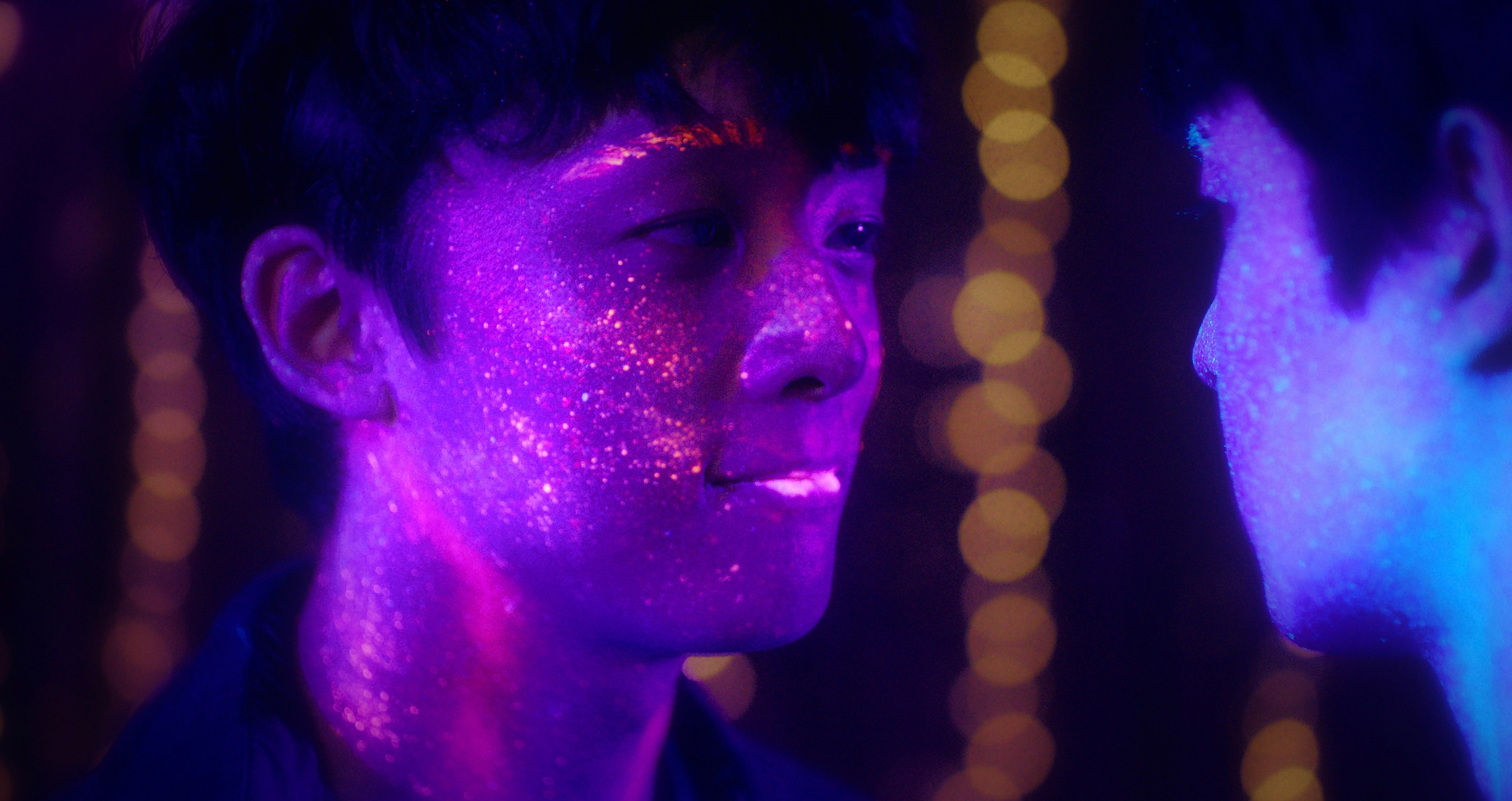 Two figures with glowing purple spots on their face look at each other.
