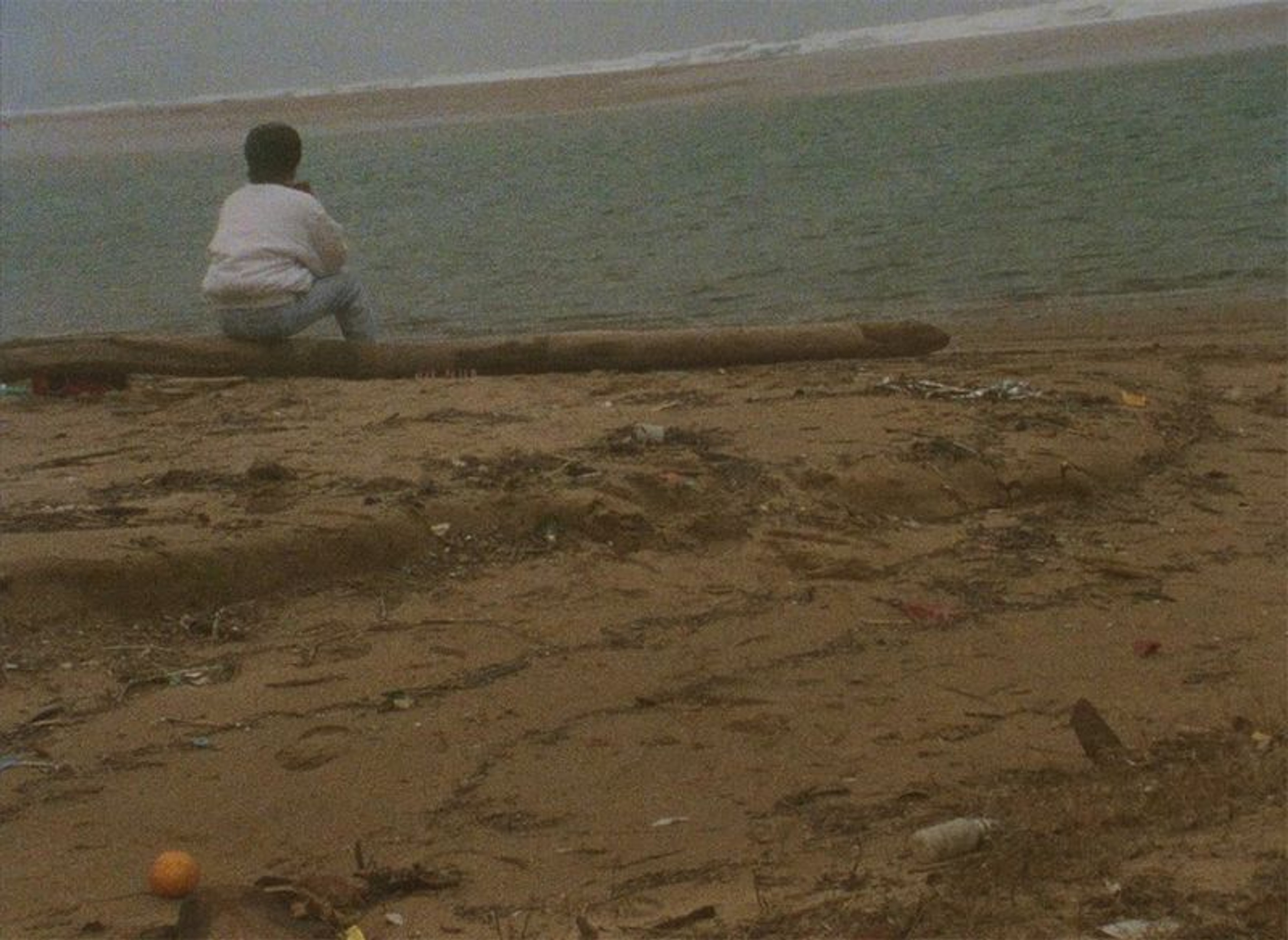 A person sitting on a beach alone.