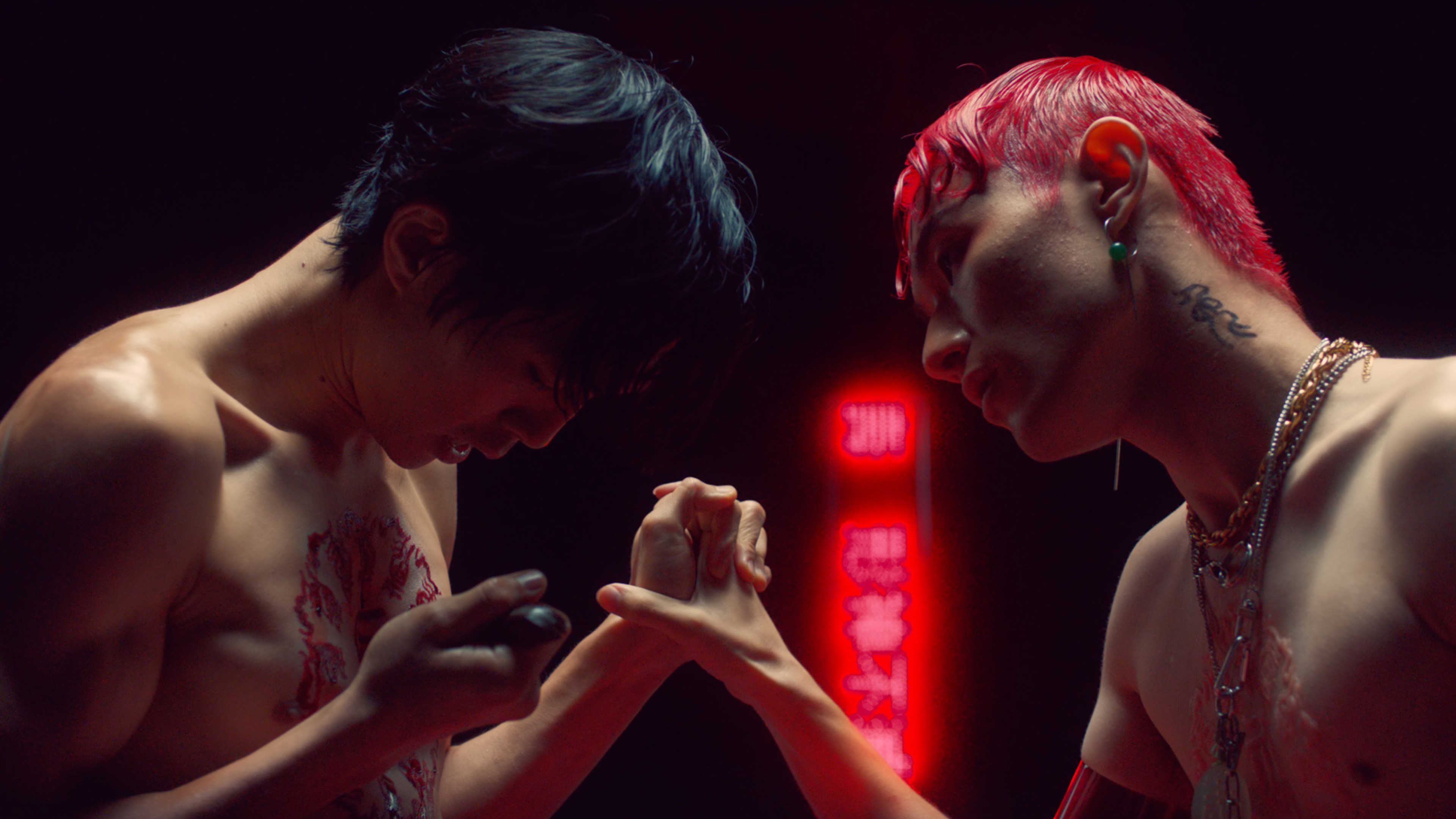 Two men clasp hands facing each other.