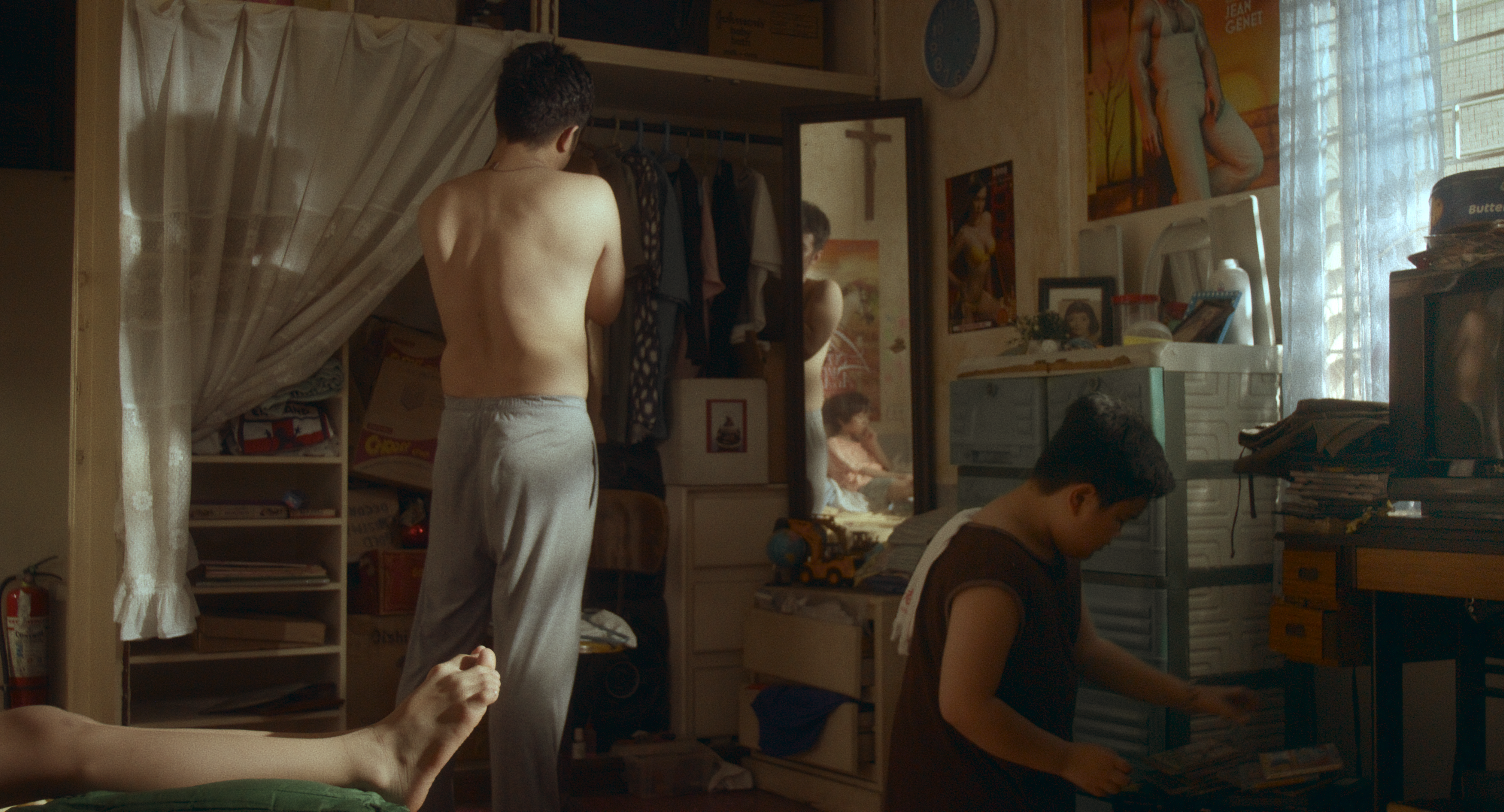 A man sorts through a wardrobe next to a boy rummaging through a box.
