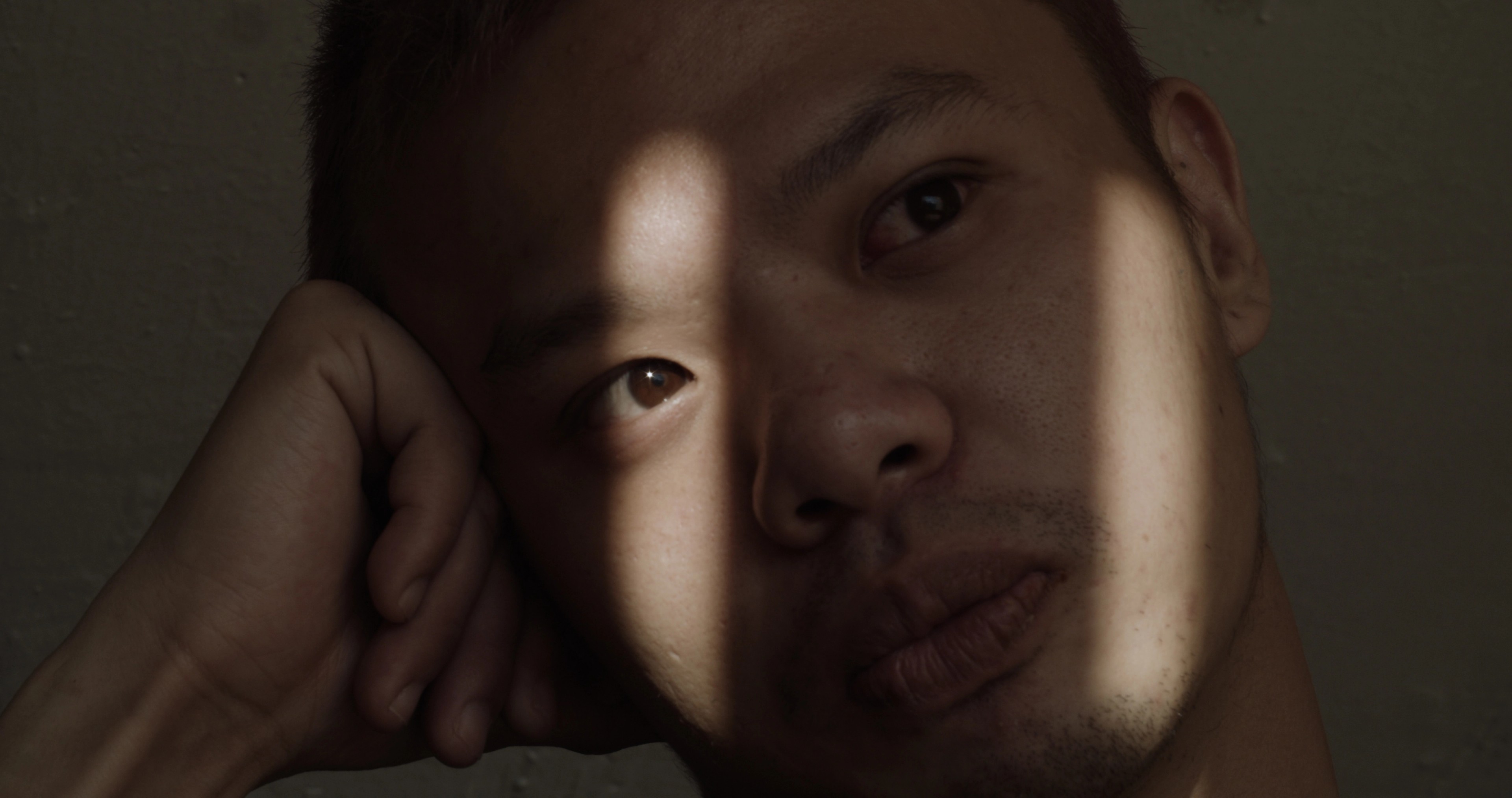 A person's face lit up by two streaks of light.