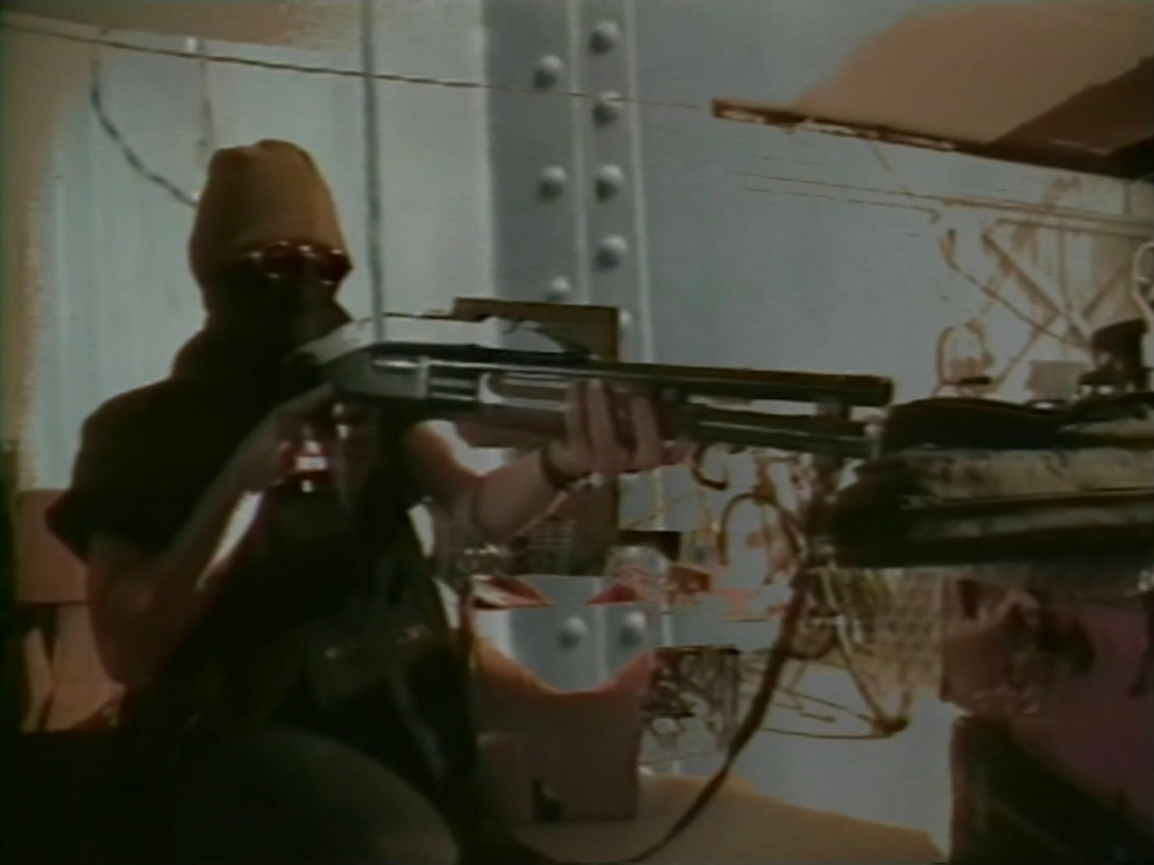A masked figure holds a shotgun.