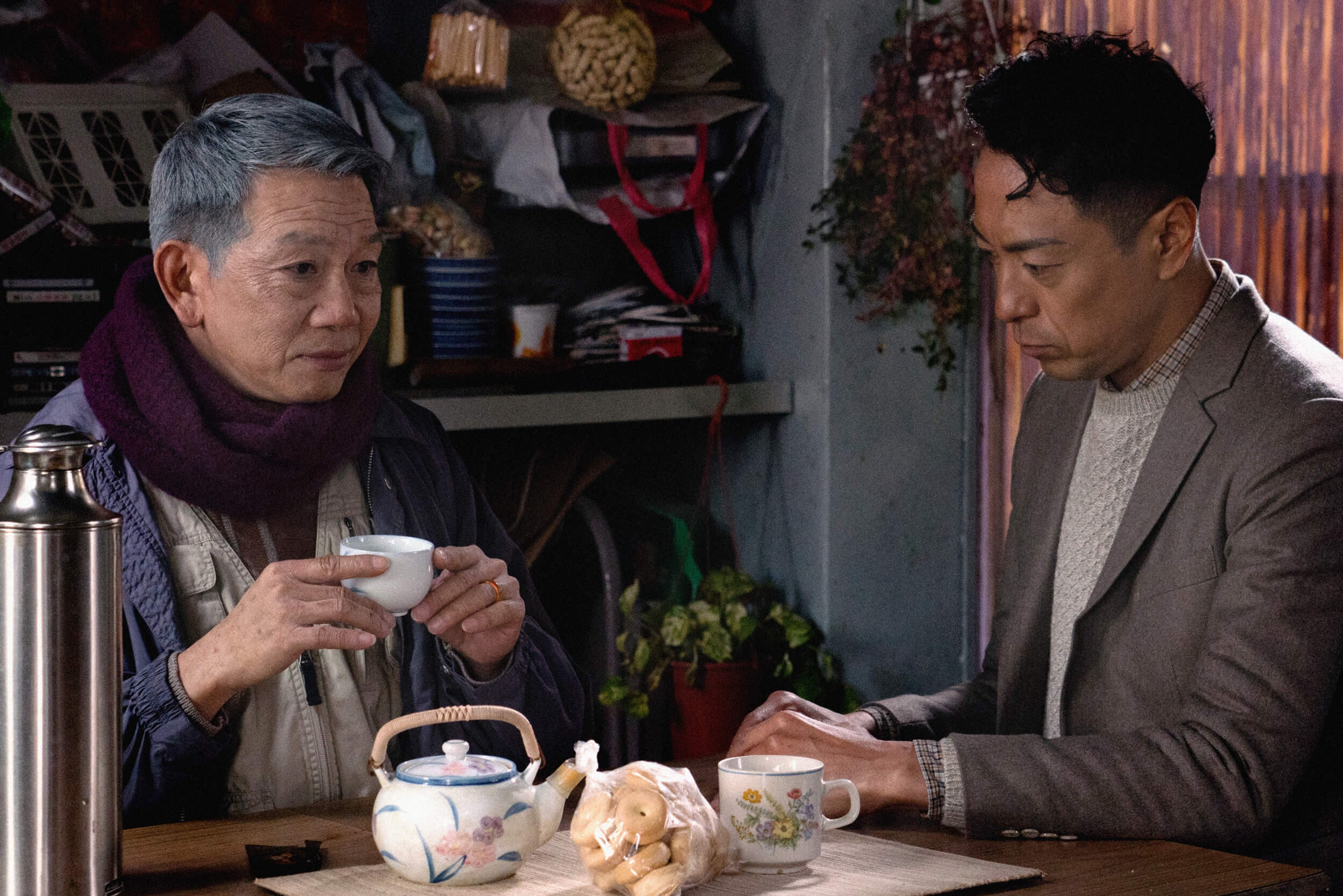 Two people sit drinking tea.