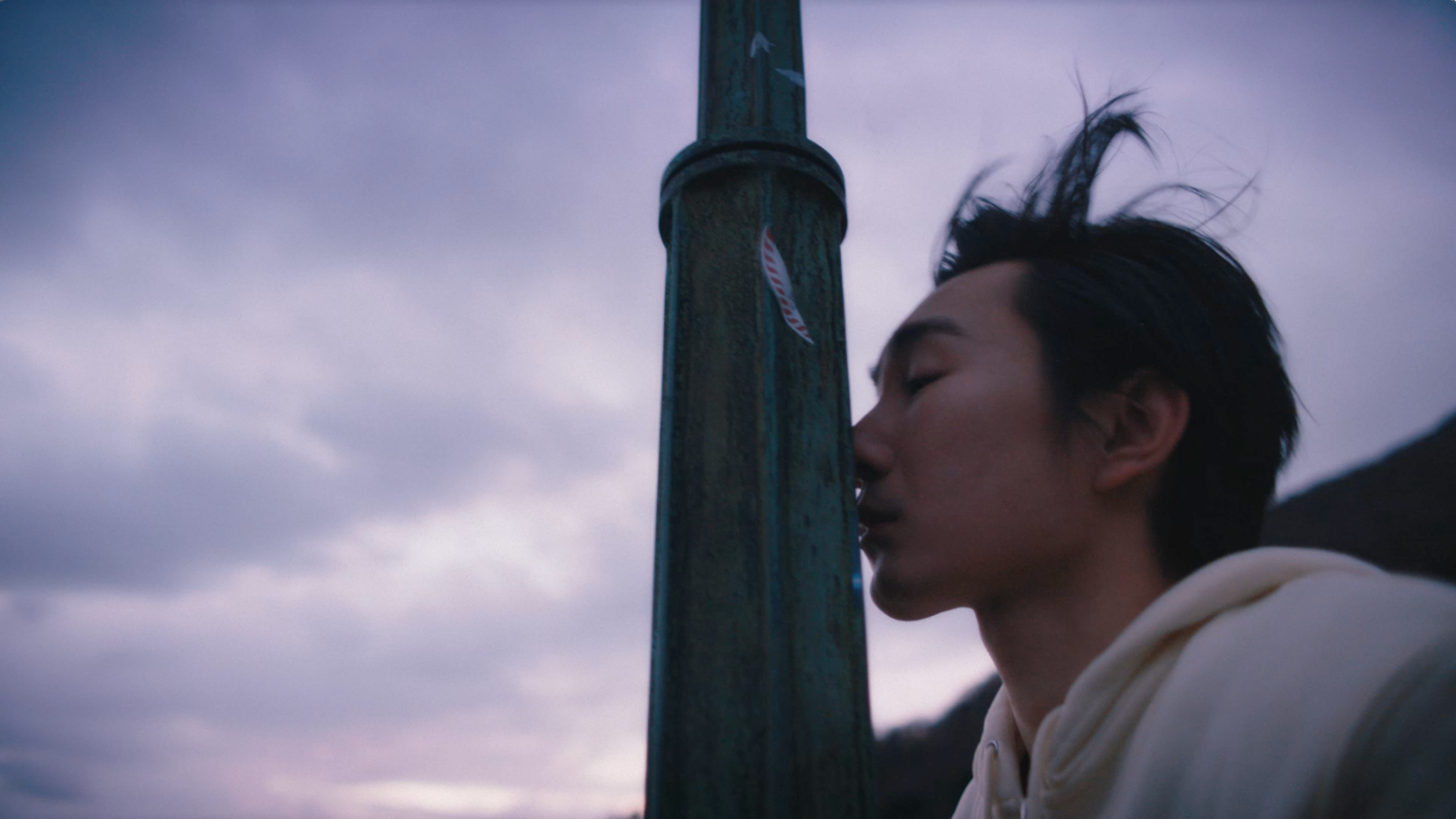 A person's side profile next to a lamp post.