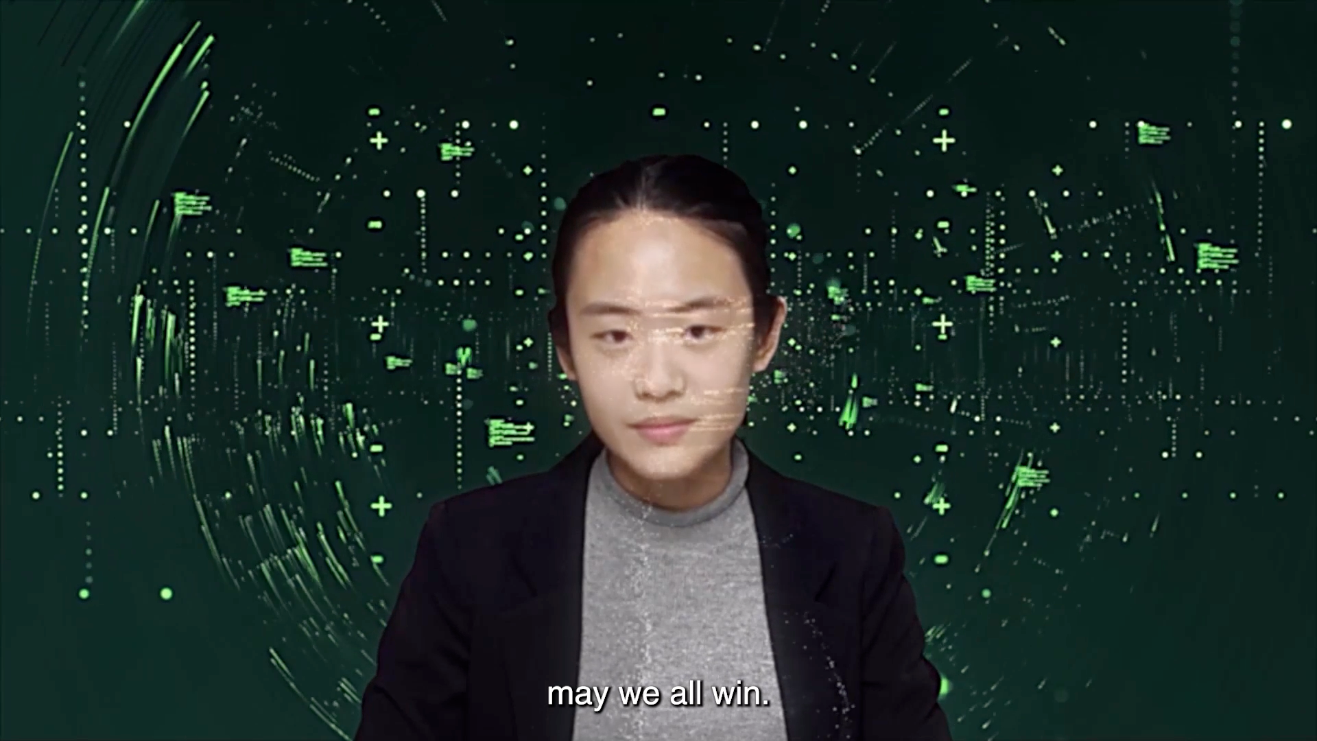 A woman in front of a green background.