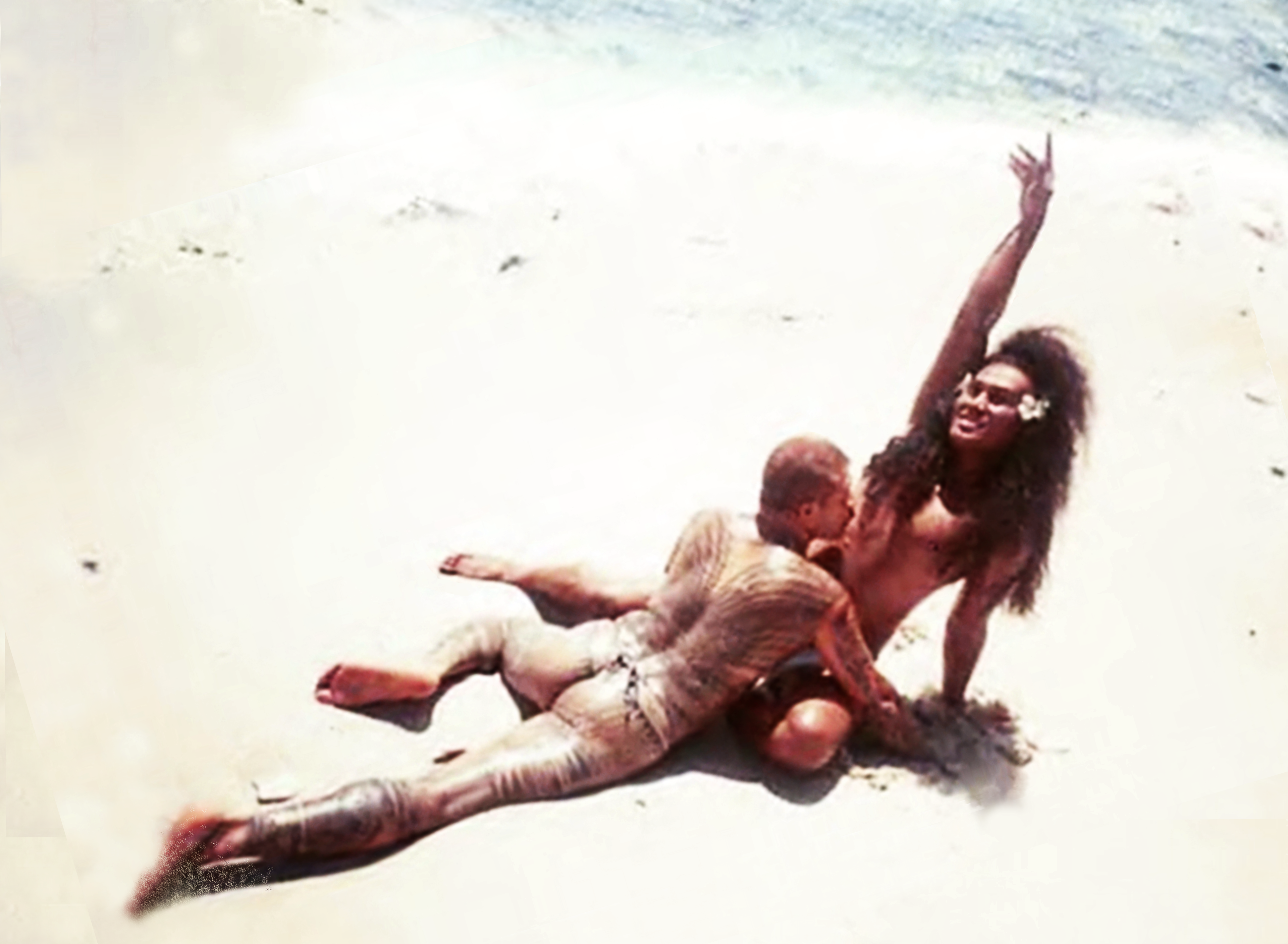 Two figures embrace on a beach.