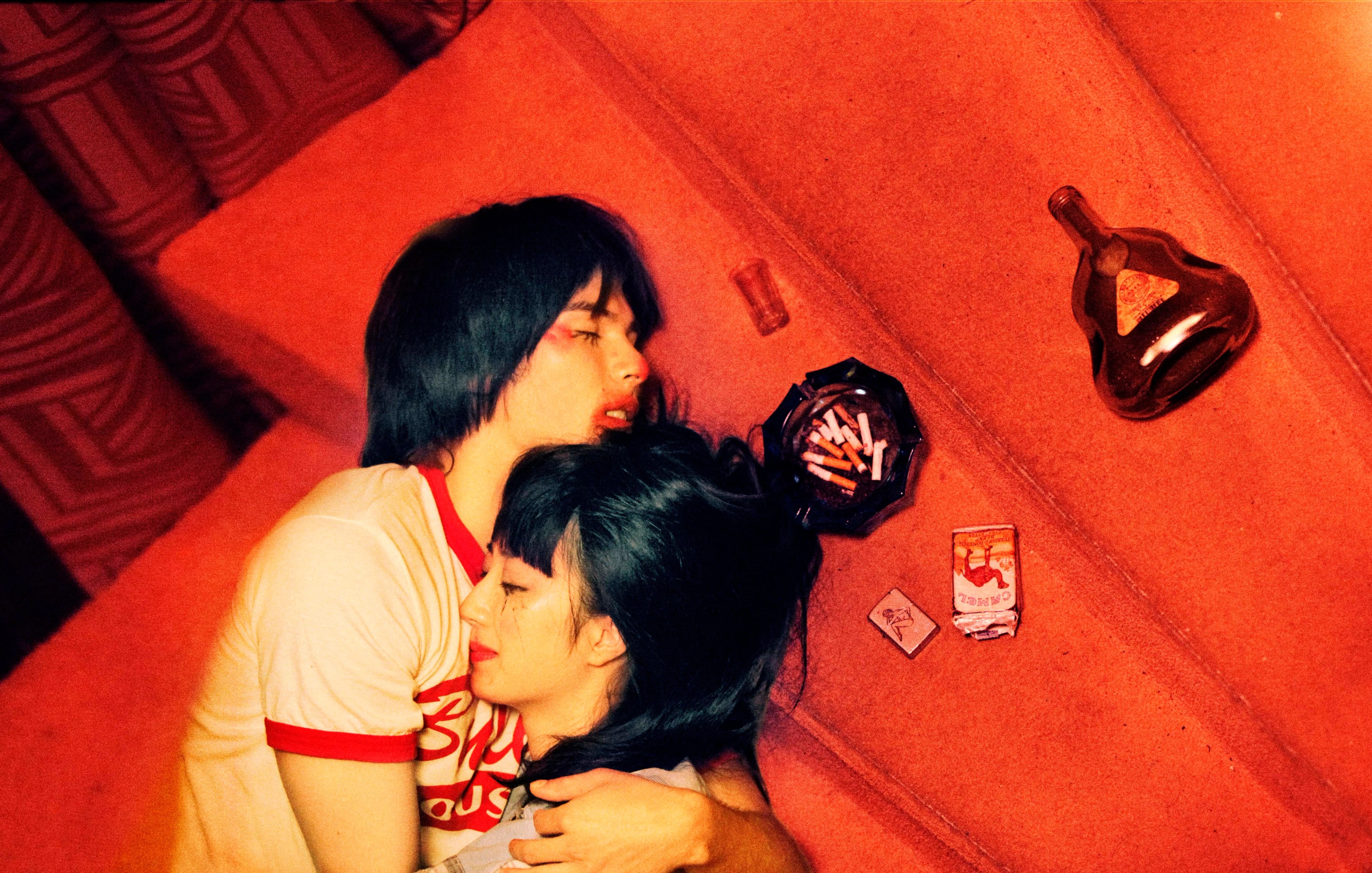 Two people hugging on a red staircase.
