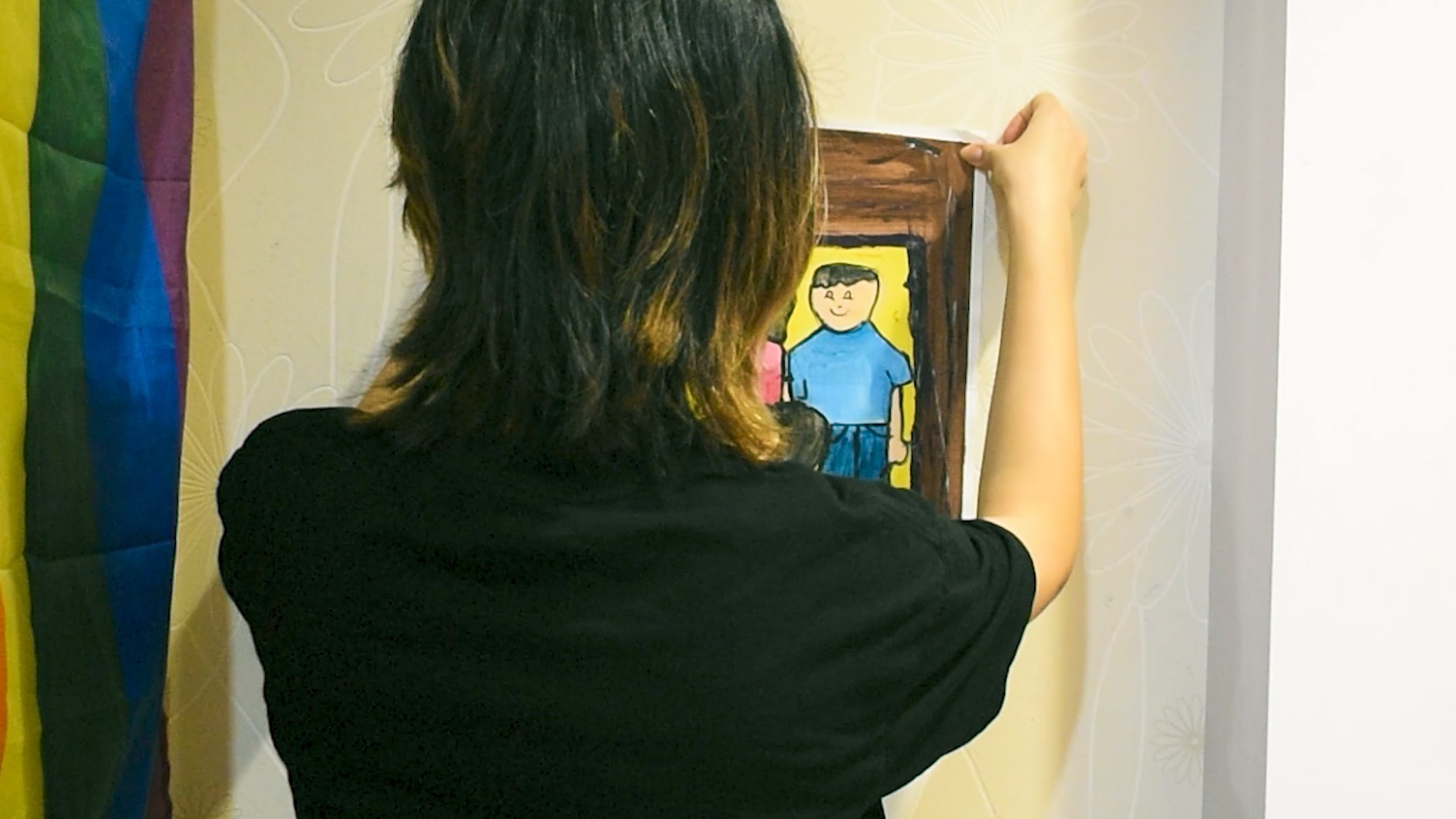 A person sticks a poster to a wall.