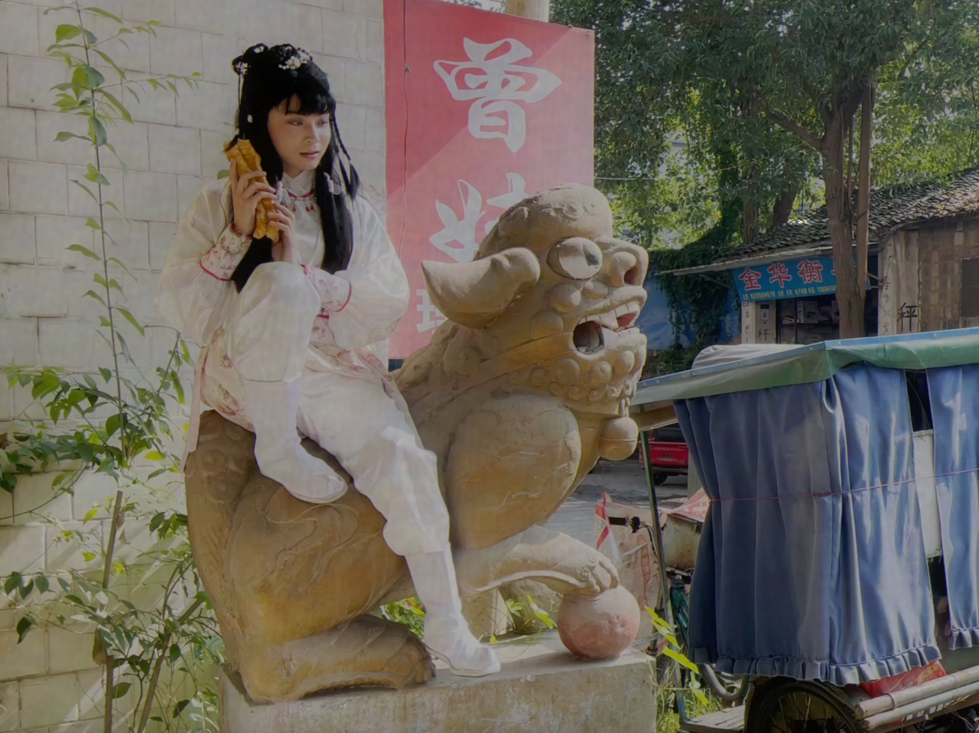 A person sitting on a stature of horned creature.