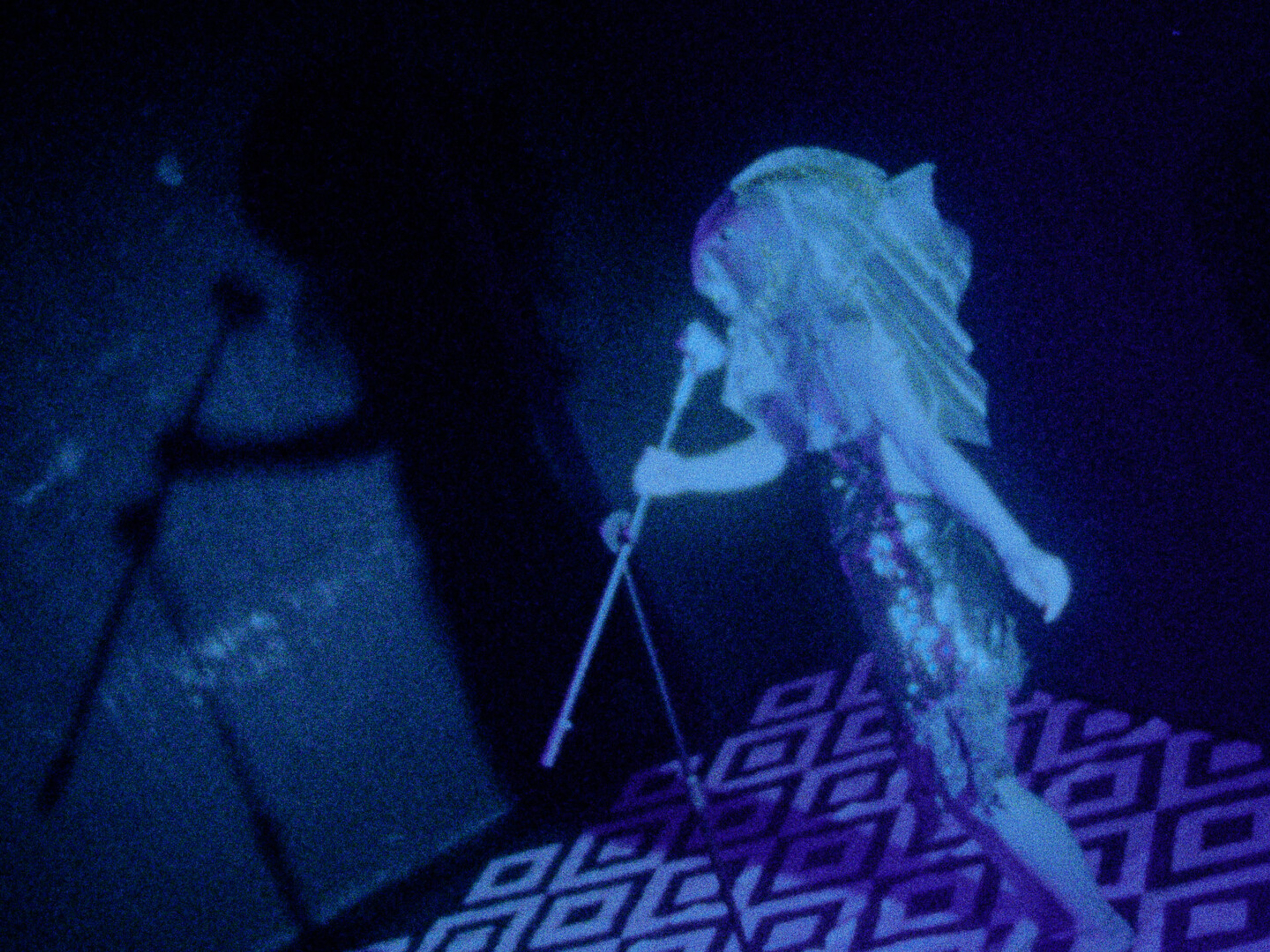 A person with a fish for a head is holding a microphone.