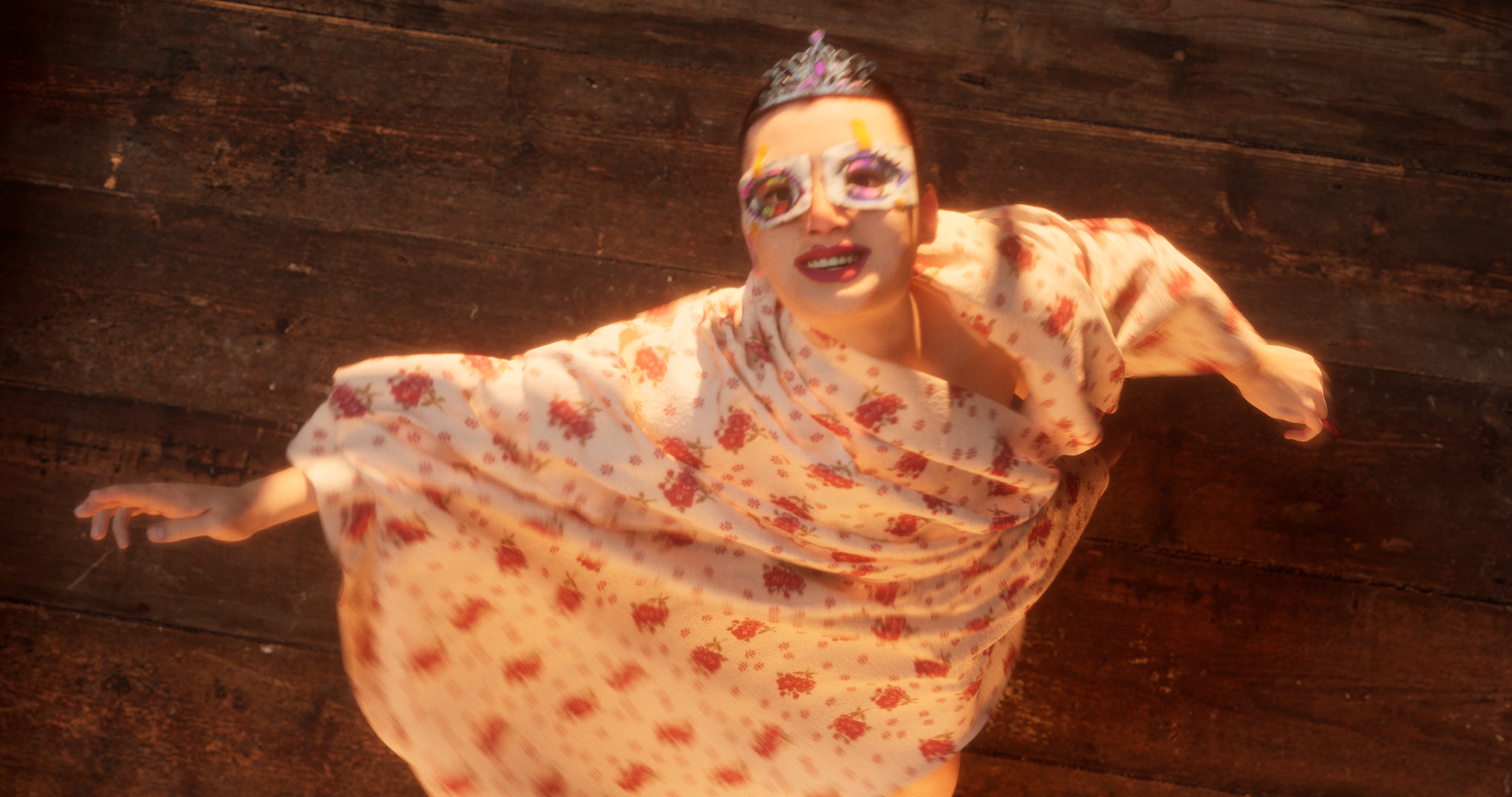 A figure wearing a crown and an eye mask.