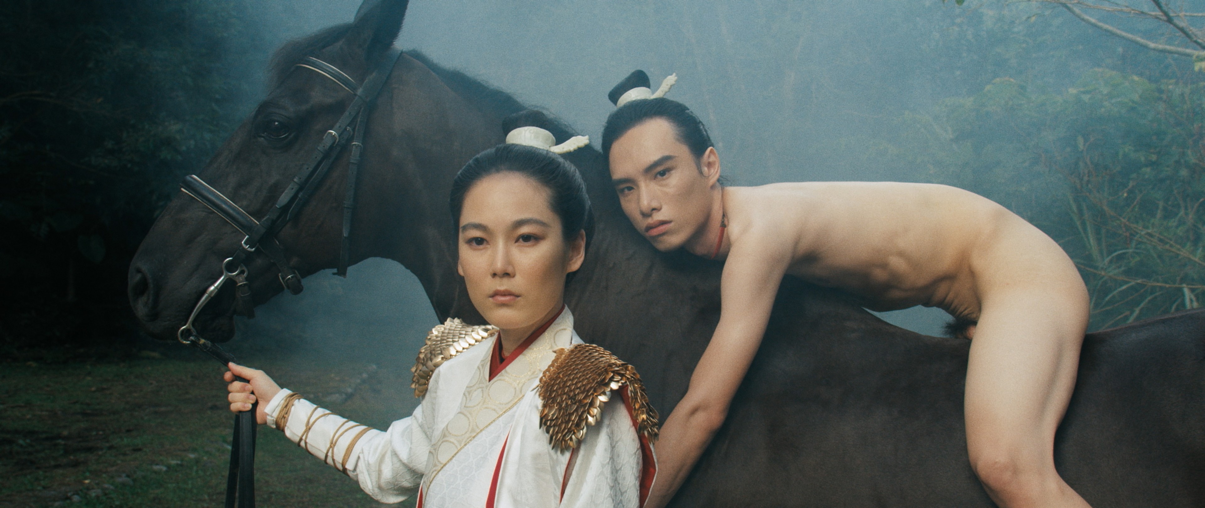 A naked person on a horse led by a person wearing white robes.