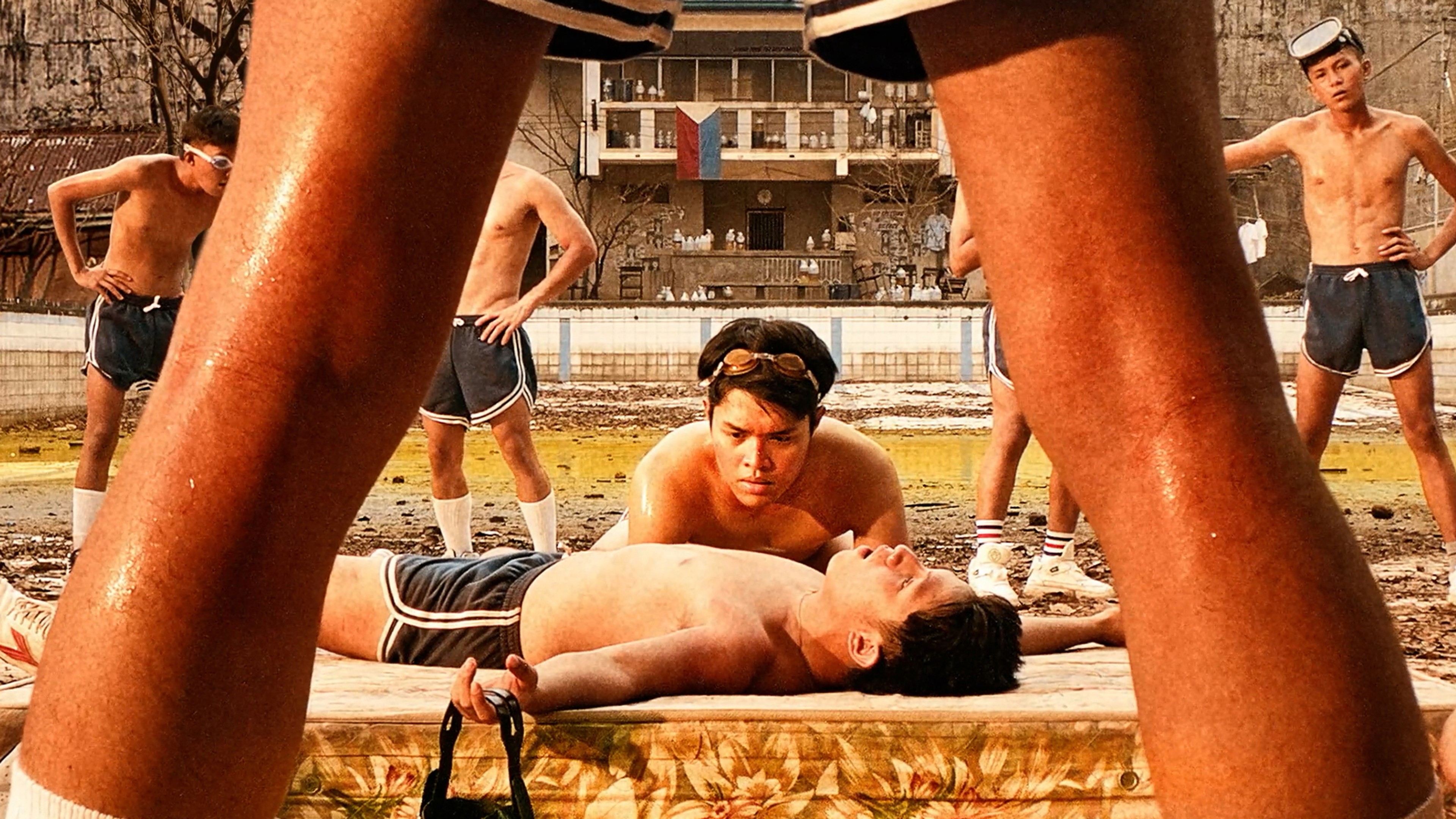 a dying boy is framed by another boy's legs.