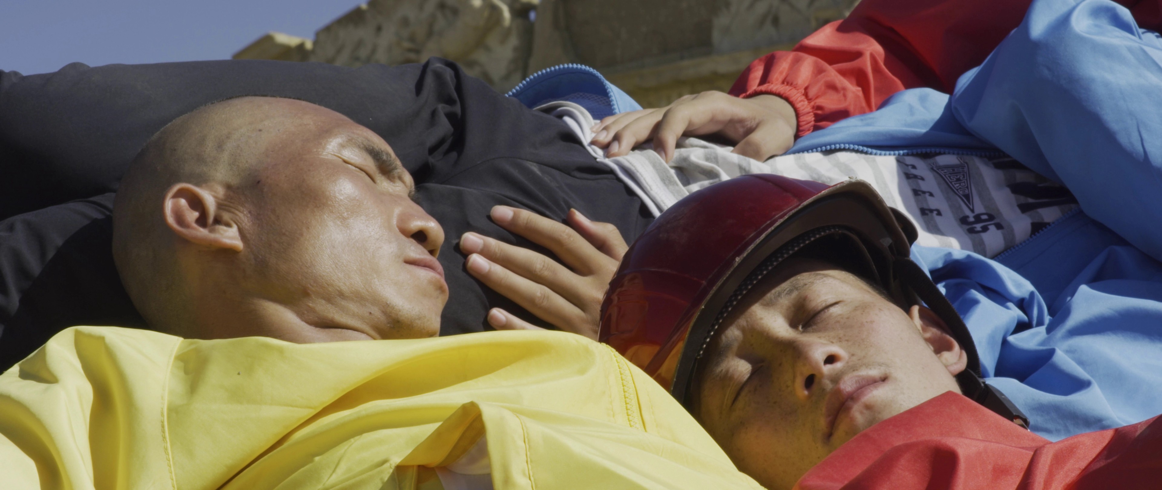 A pile of men sleeping on top of each other.