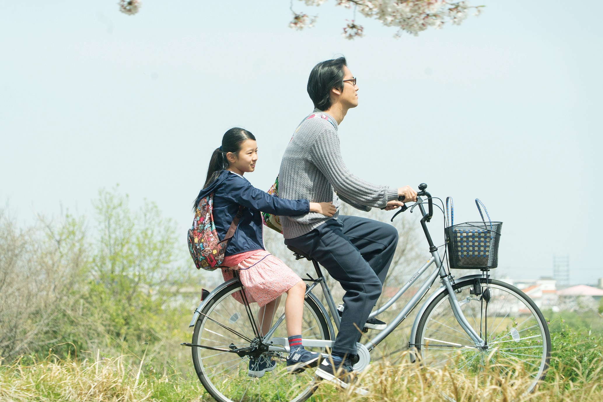 An adult and a child on a bicycle.