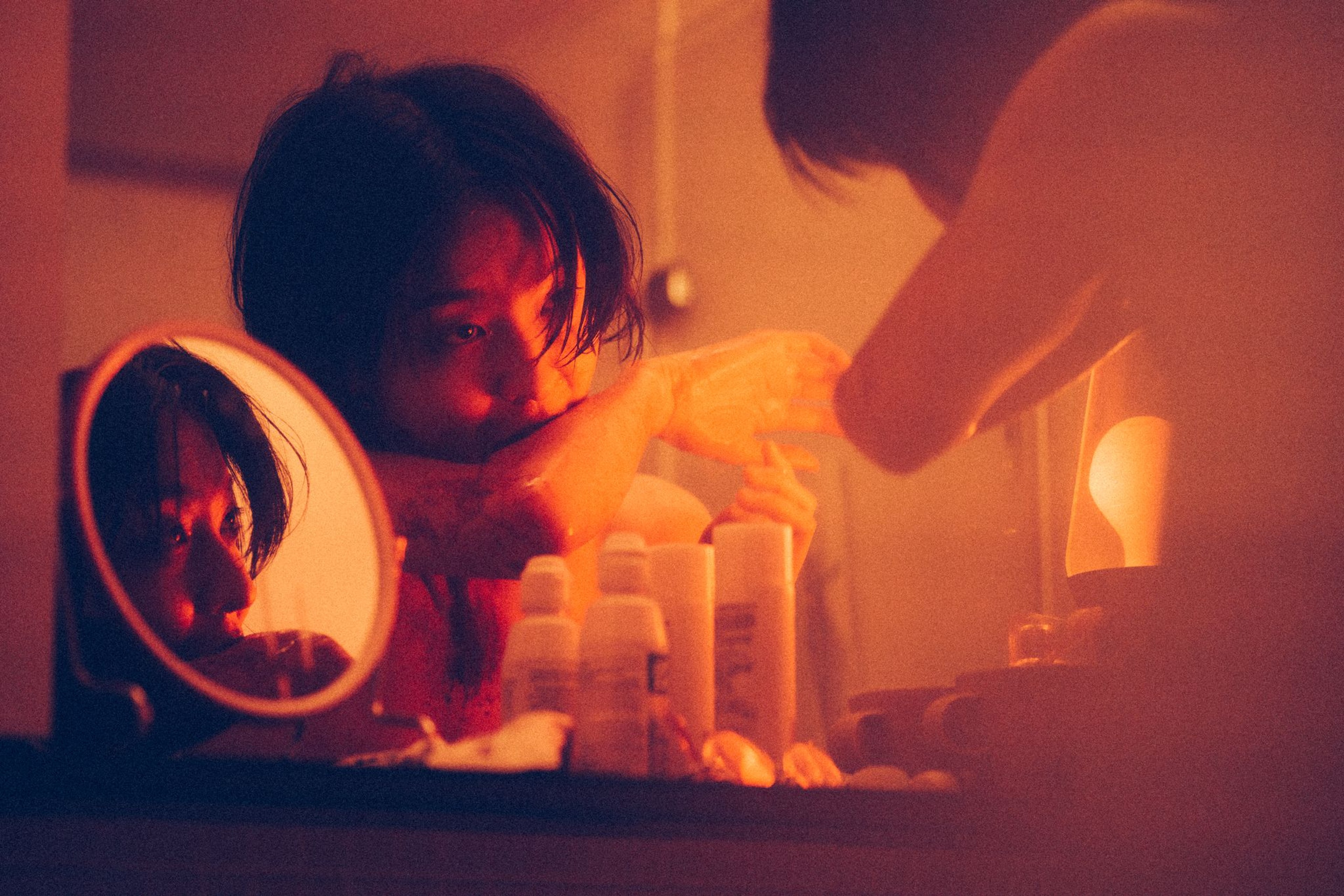 A person biting their arm in front of a mirror.