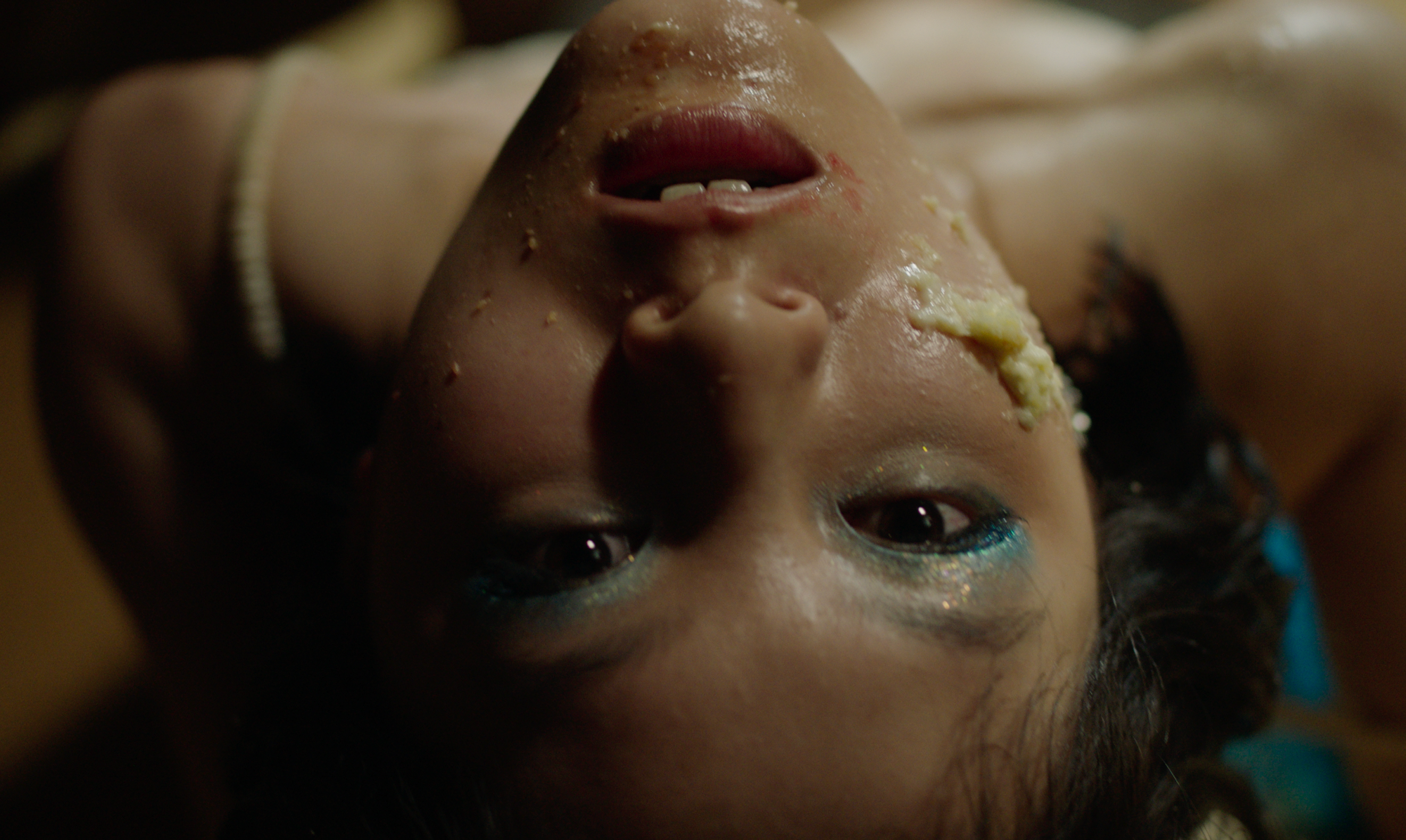 an upside-down person with cake on their face.