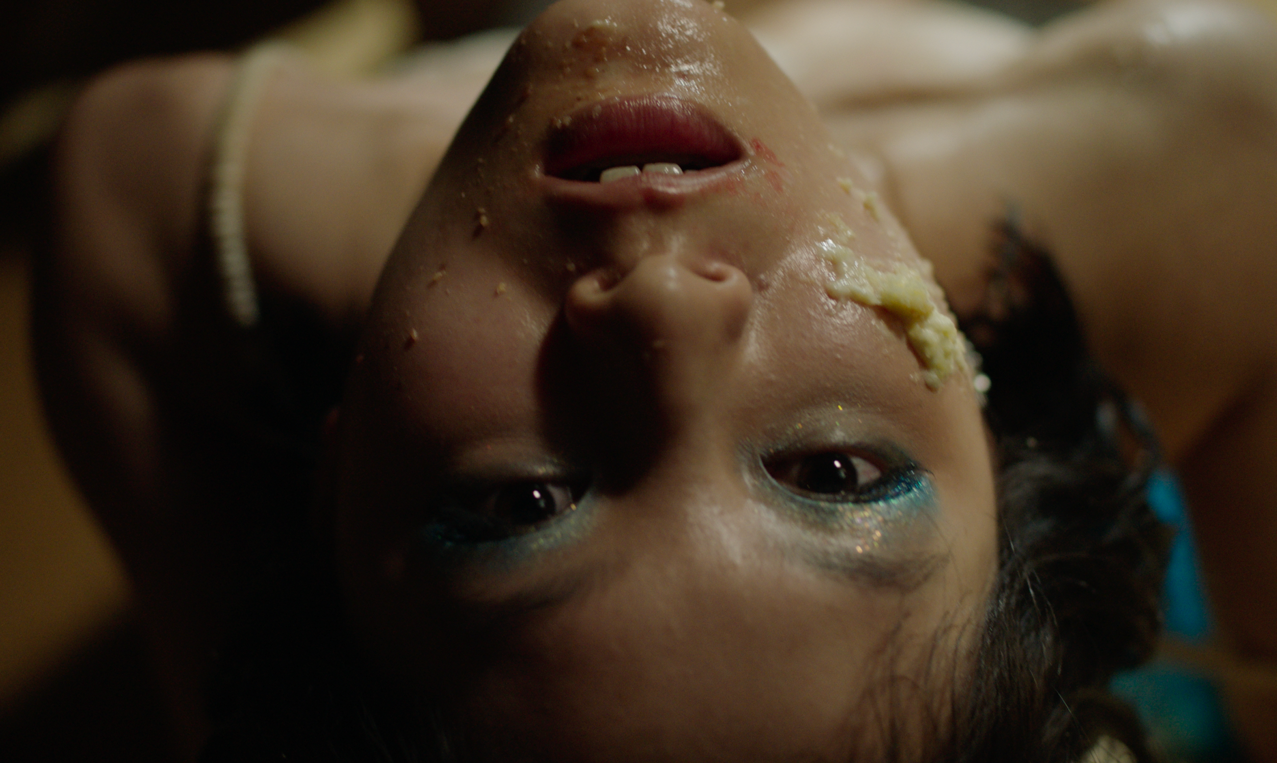 an upside-down person with cake on their face.