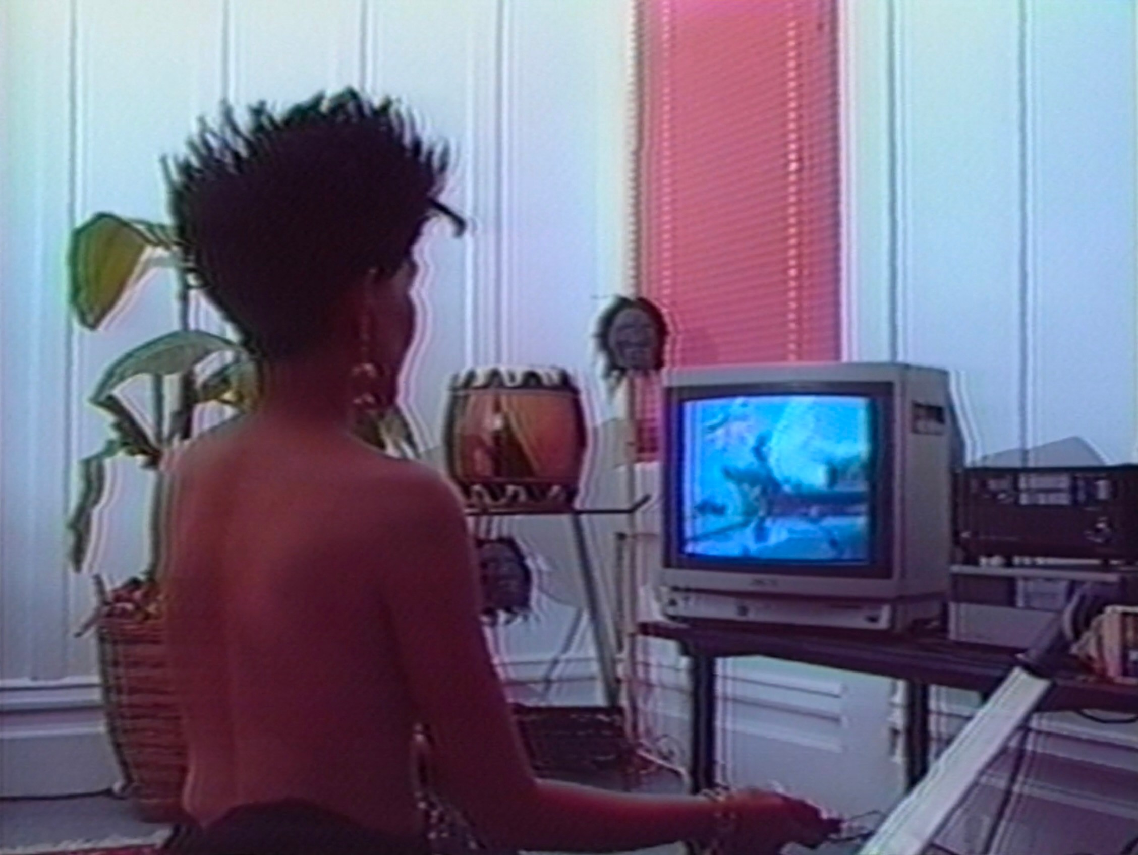 A topless person watches TV.