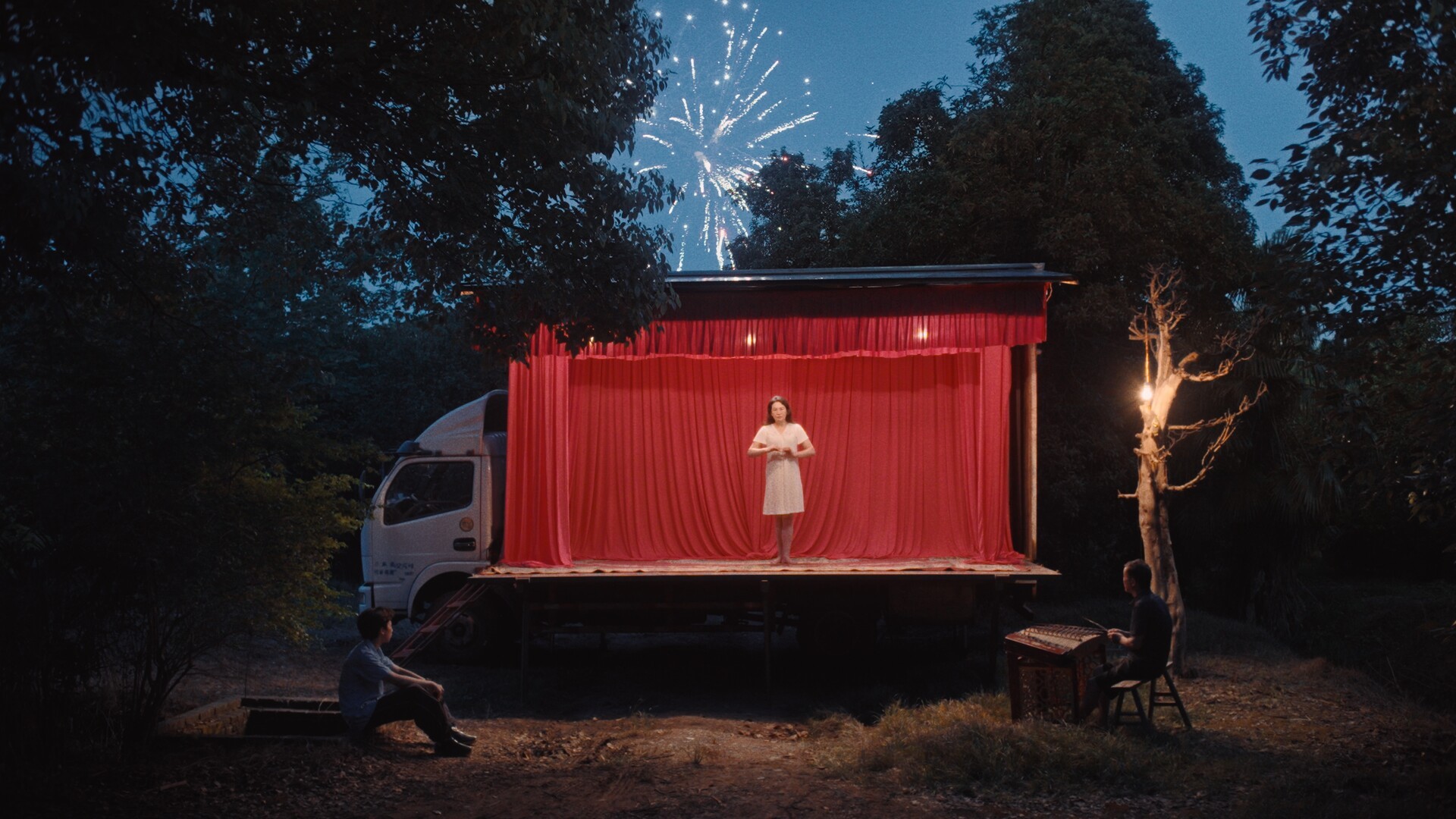 A woman stands on a stage inside of a truck.