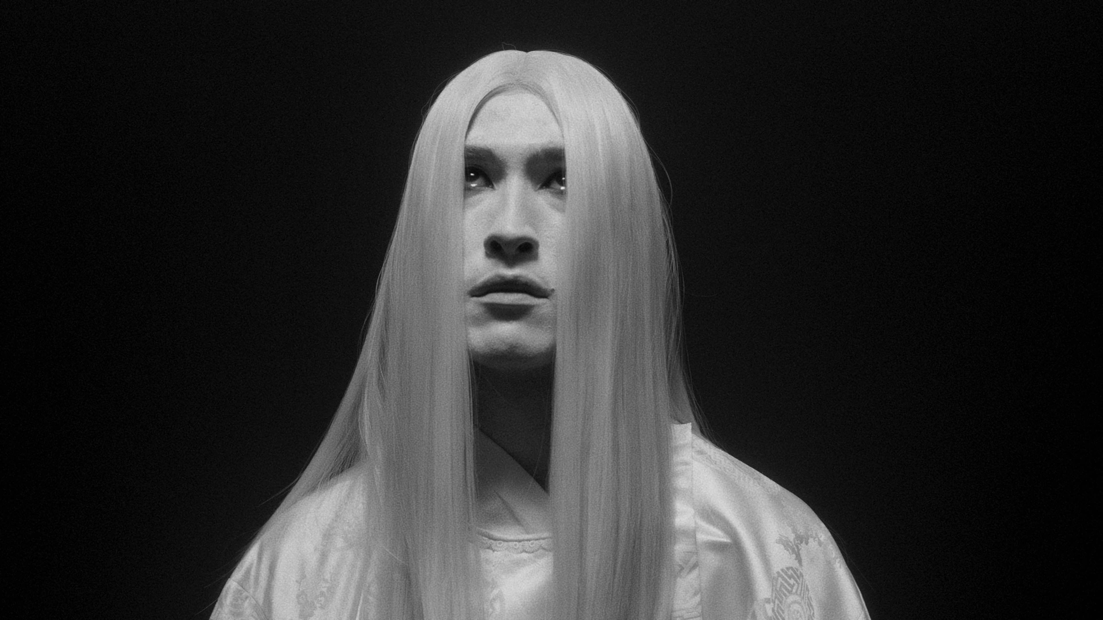 A person with long straight hair covering their face