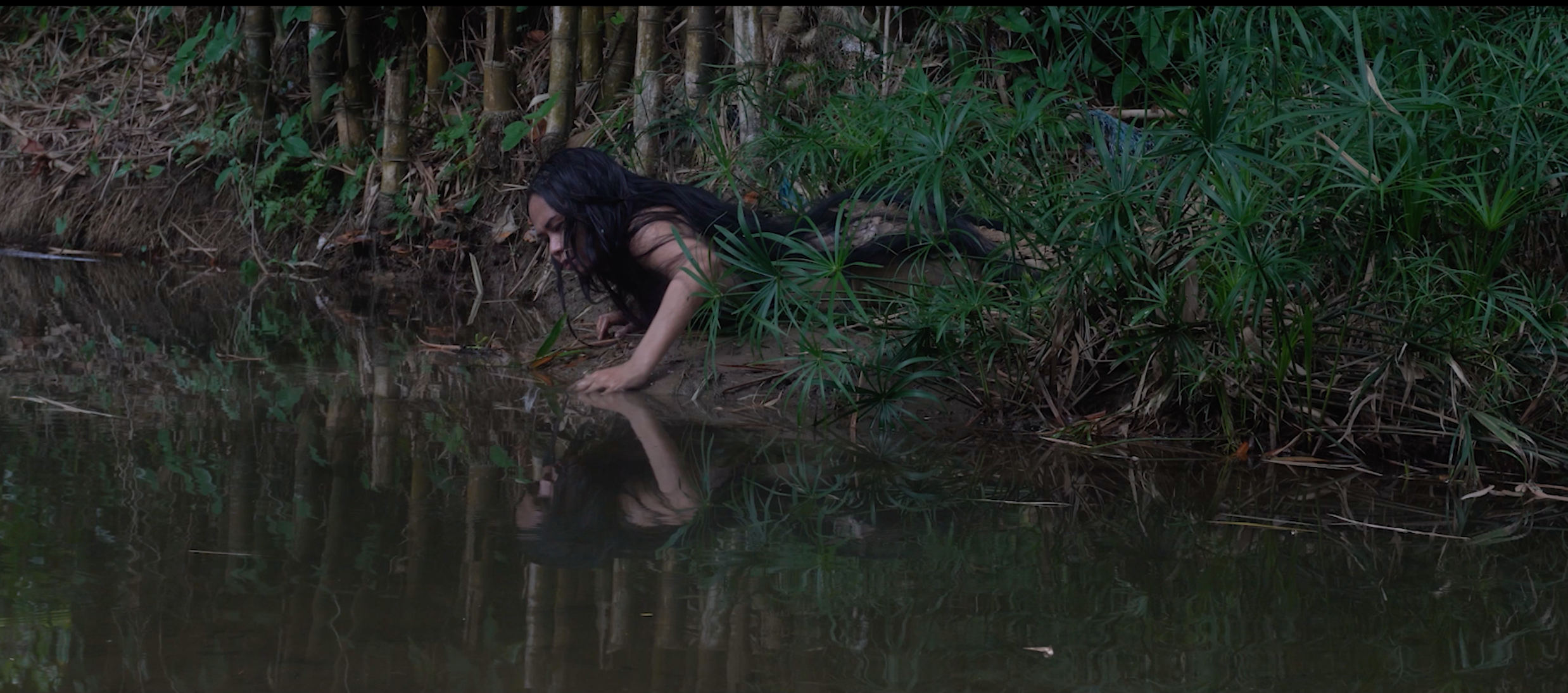A woman crawling across the riverbank.