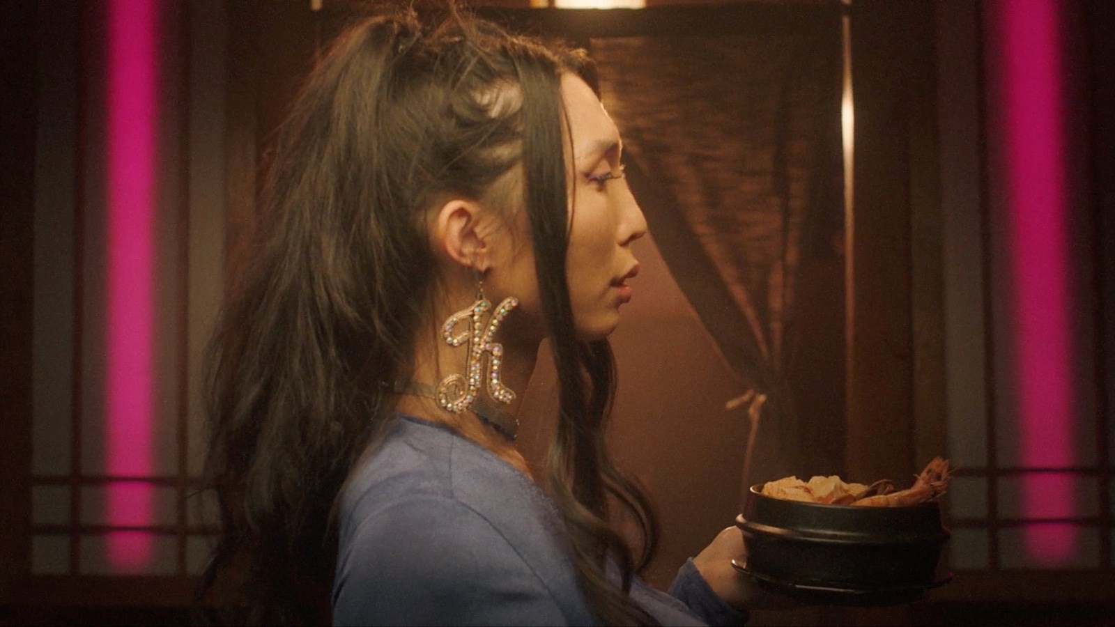 the side-profile of a woman holding a bowl of soup.