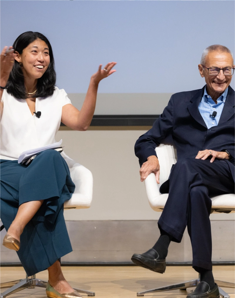 USPA Vice President Aliya Haq on stage with presidential advisor John Podesta