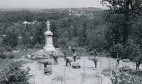 CCC laborers at work around a Civil War monument at Gettysburg, with the battlefield landscape beyond — historical photo