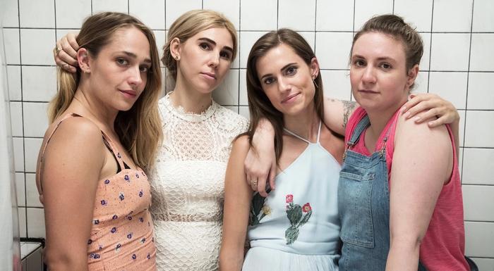 The cast of GIRLS standing in front of a while tile wall