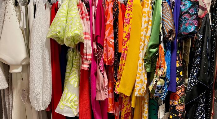 A colorful assortment of clothes hanging on a rack