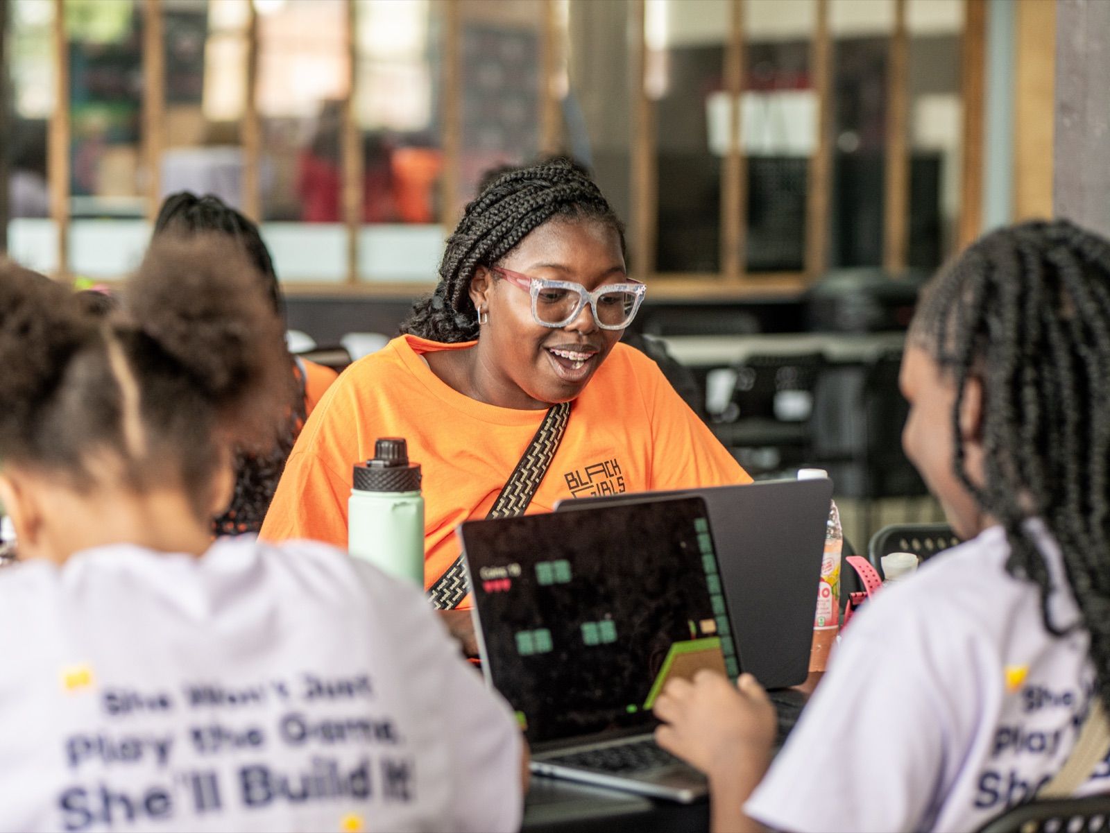 Rayne, 13, laughing at her laptop during camp