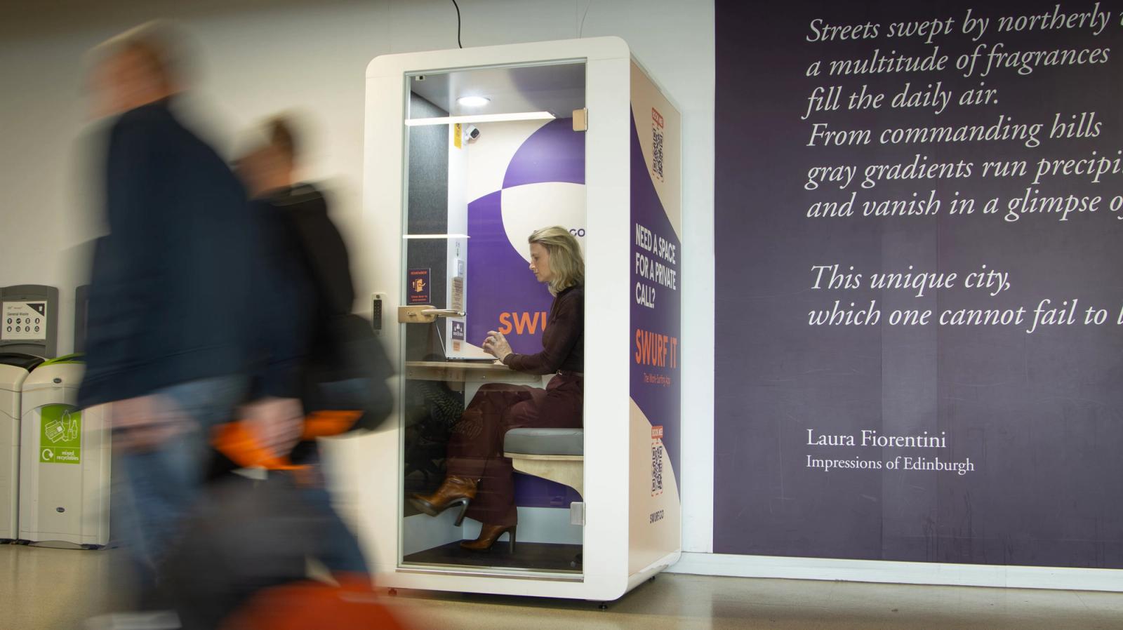 A business traveller working in a SWURF pod at Edinburgh Airport