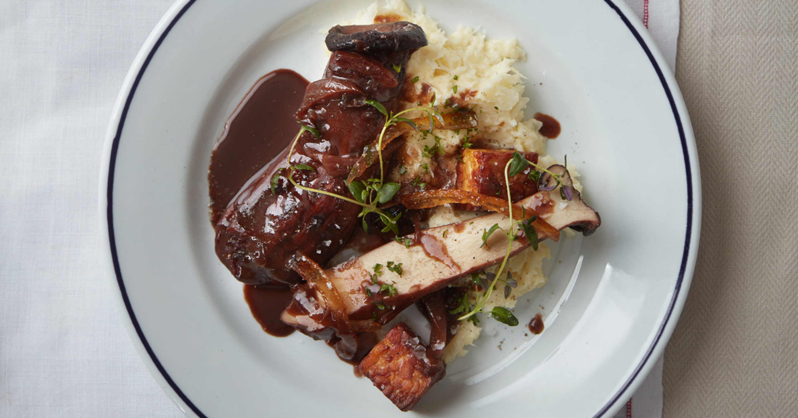 Rødvinsbraiserede kejserhatte med pomerans, sort miso, ristet tempeh  og cremet vinterkål