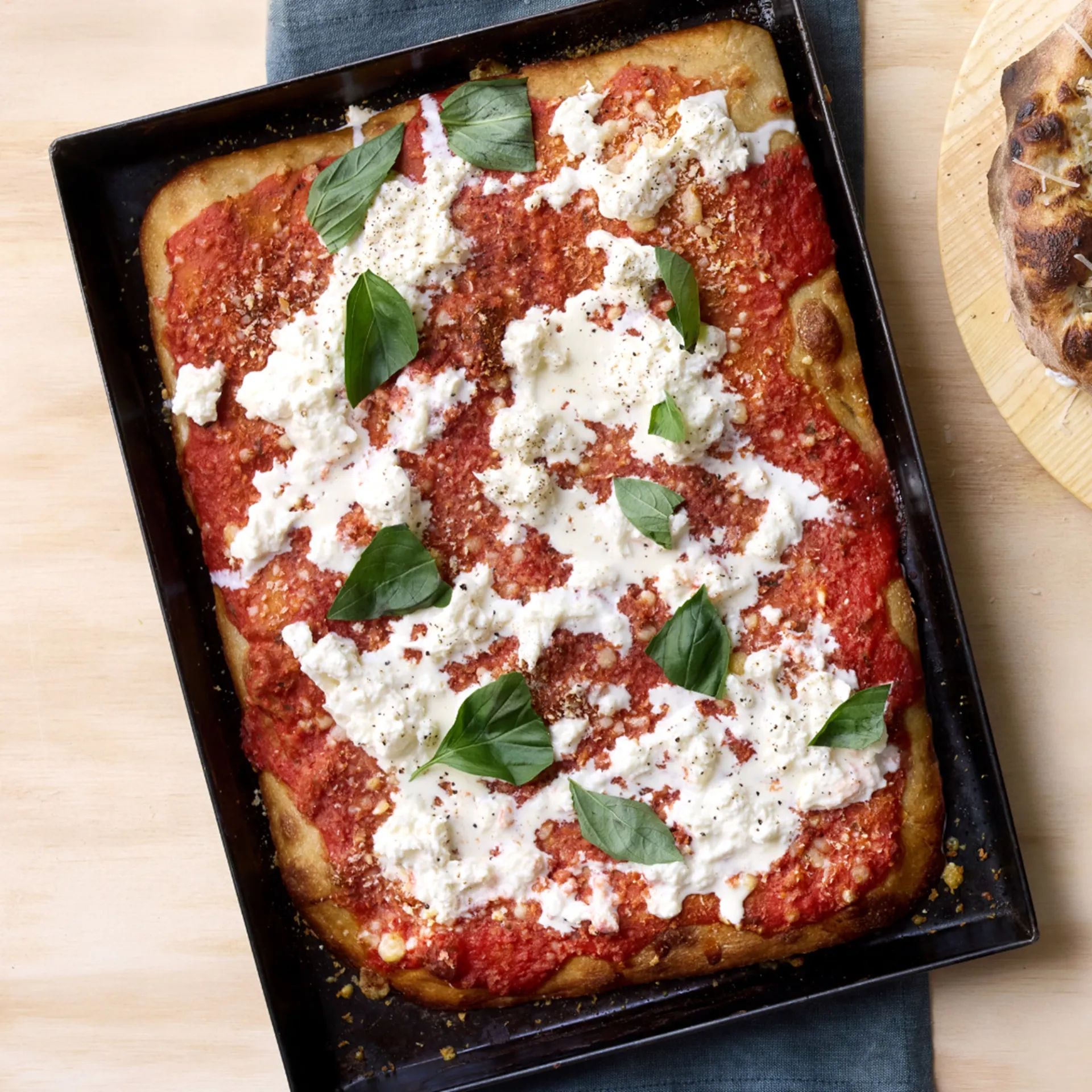 Rød bradepandepizza med brødkrummer, stracciatella og basilikum