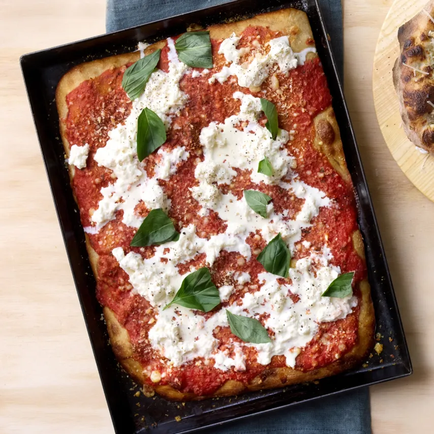 Rød bradepandepizza med brødkrummer, stracciatella og basilikum