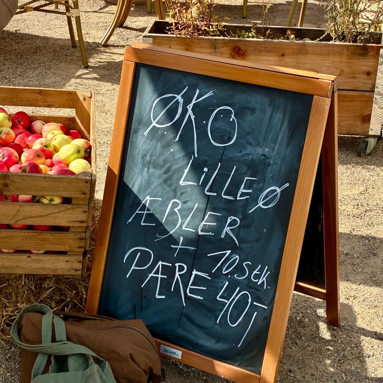 Kasser med økologiske æbler og en kridttavle med æbler og pærer fra Lilleø