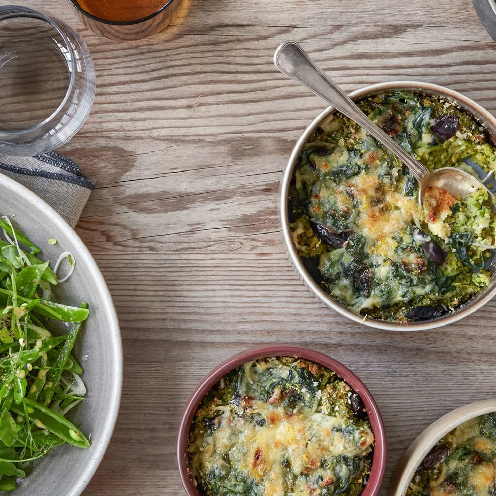Gratineret kikærtefars med spinat, ærter og oliven