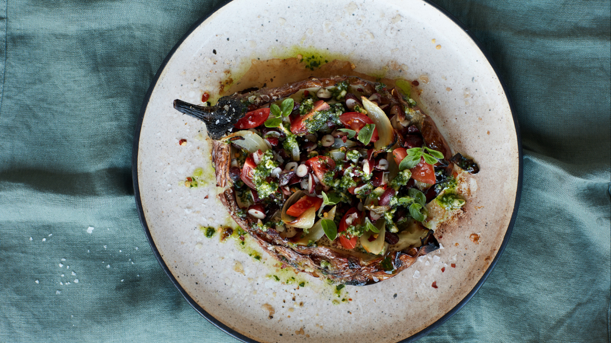 Ristede auberginer med bønne-tomatfyld, bagte løg, chili og basilikumpesto