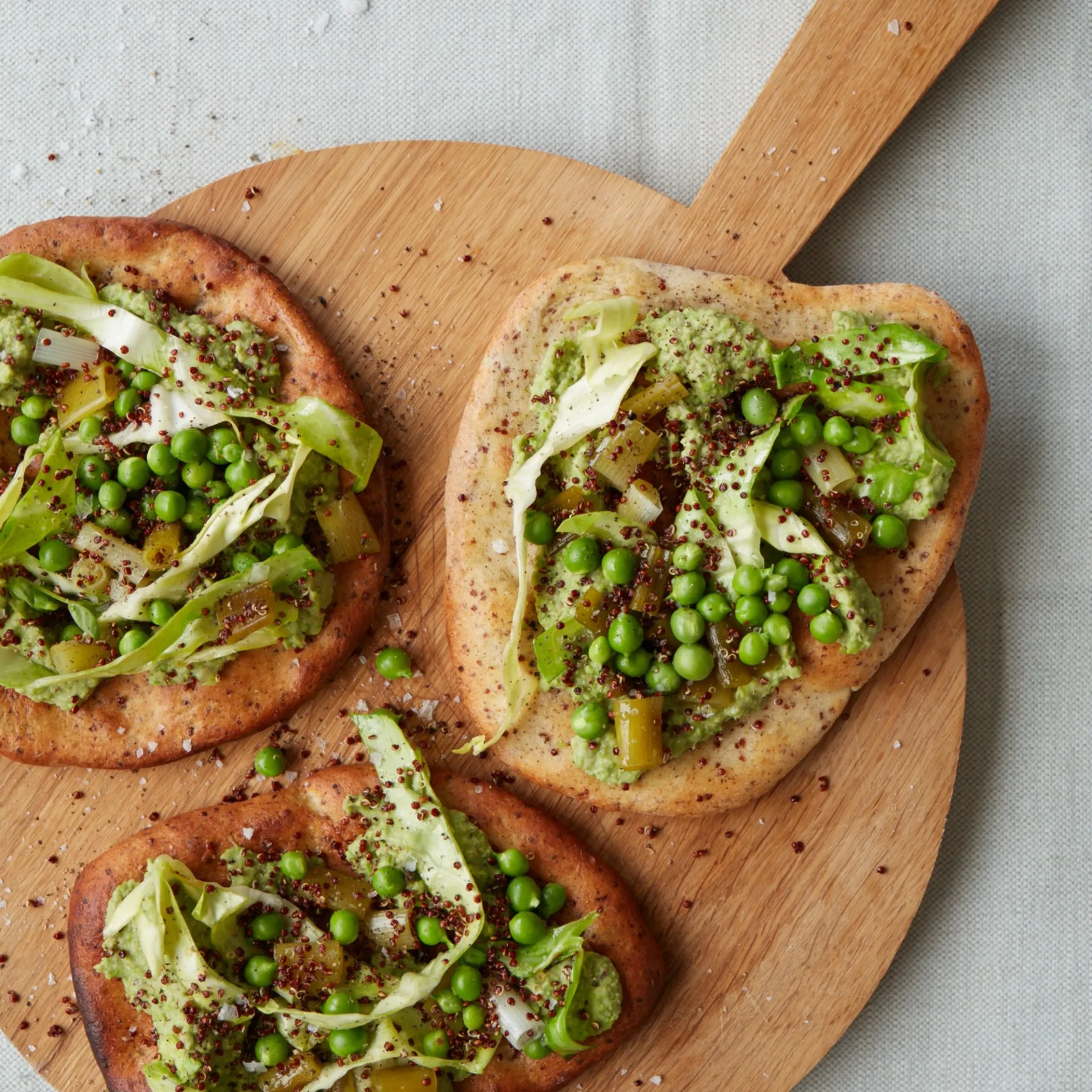 Mungbønne-ærtepuré med lynstegt spidskål og syltede forårsløg på quinoafladbrød