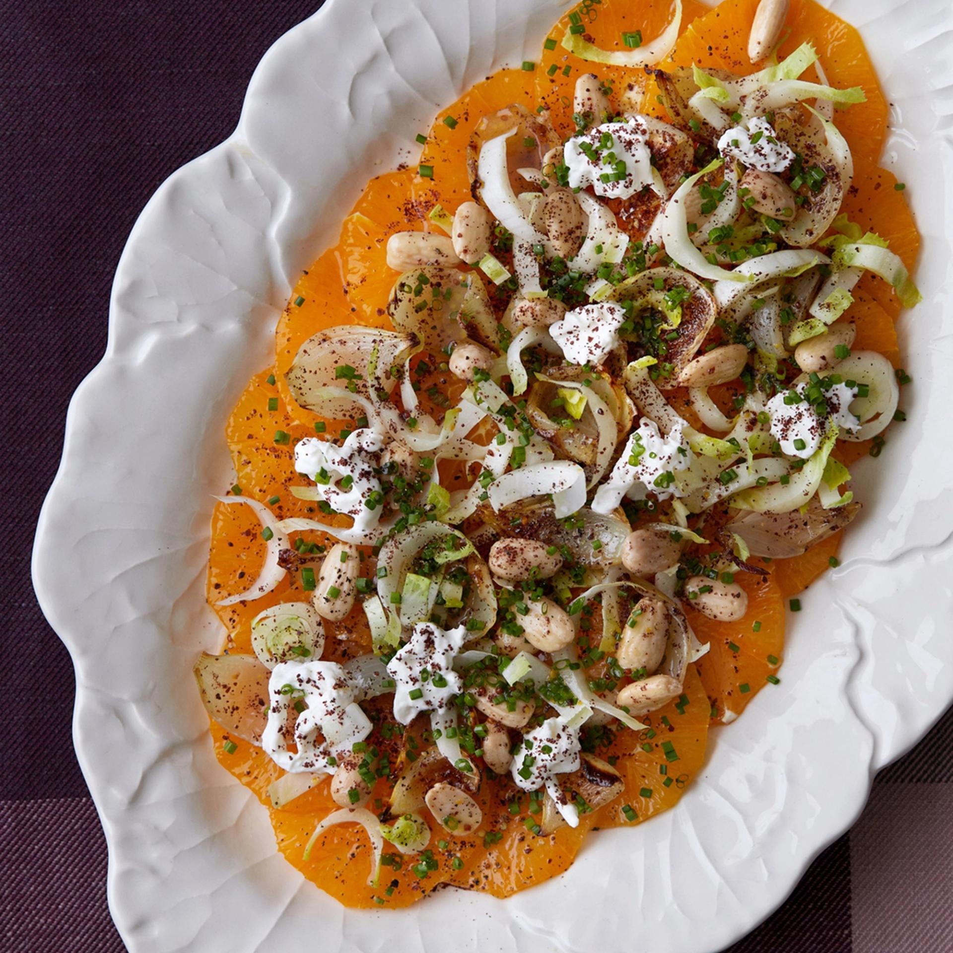 Salat af appelsiner og julesalat med sumakbagte løg, burrata og saltristede mandler