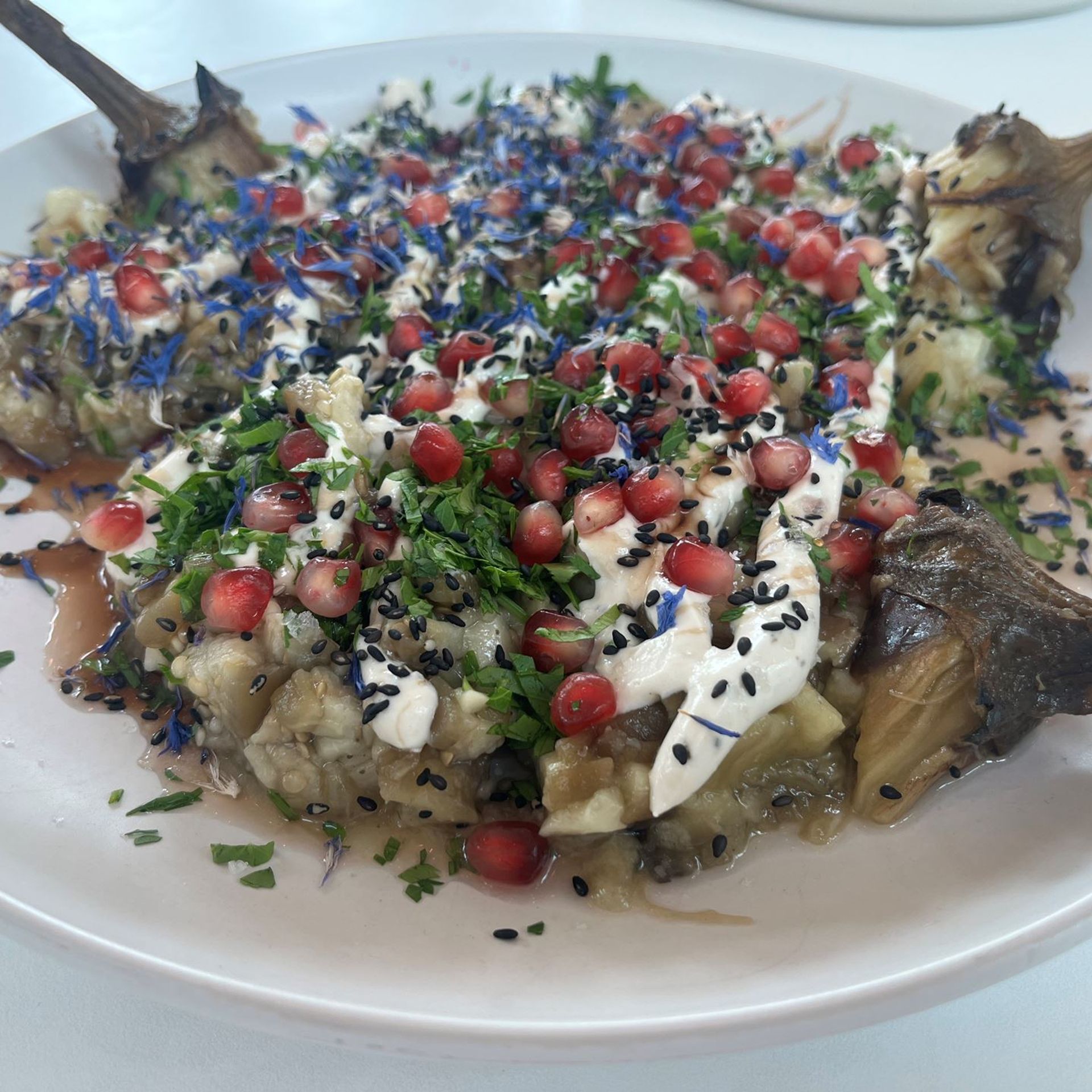 Brændte auberginer med granatæble, sort sesam og tahindressing