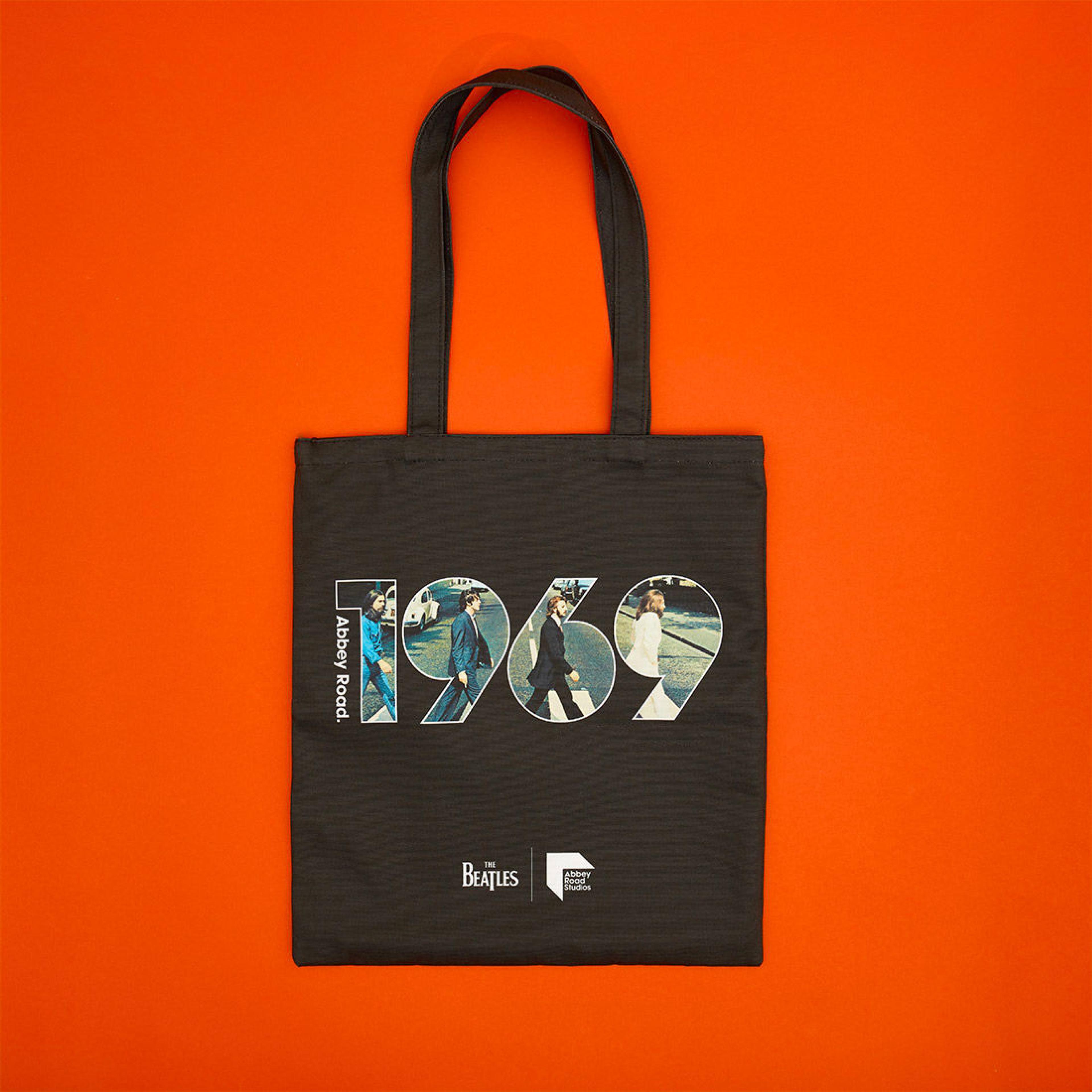Black tote back with a graphic which shows the cover image from the Beatles album 'Abbey Road' inside of some type which reads '1969'.